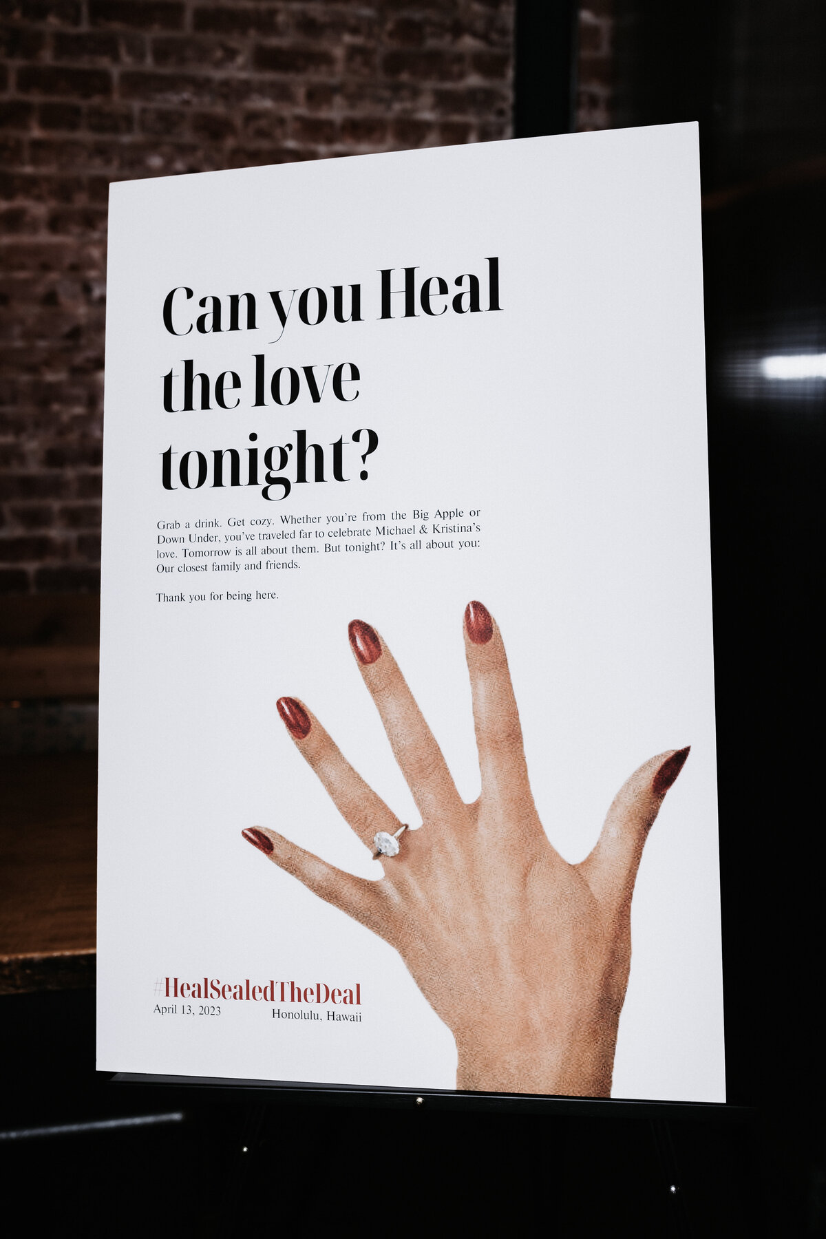 Sign that reads, Can you heal the love tongiht? with a photo of a hand and an engagement ring on it