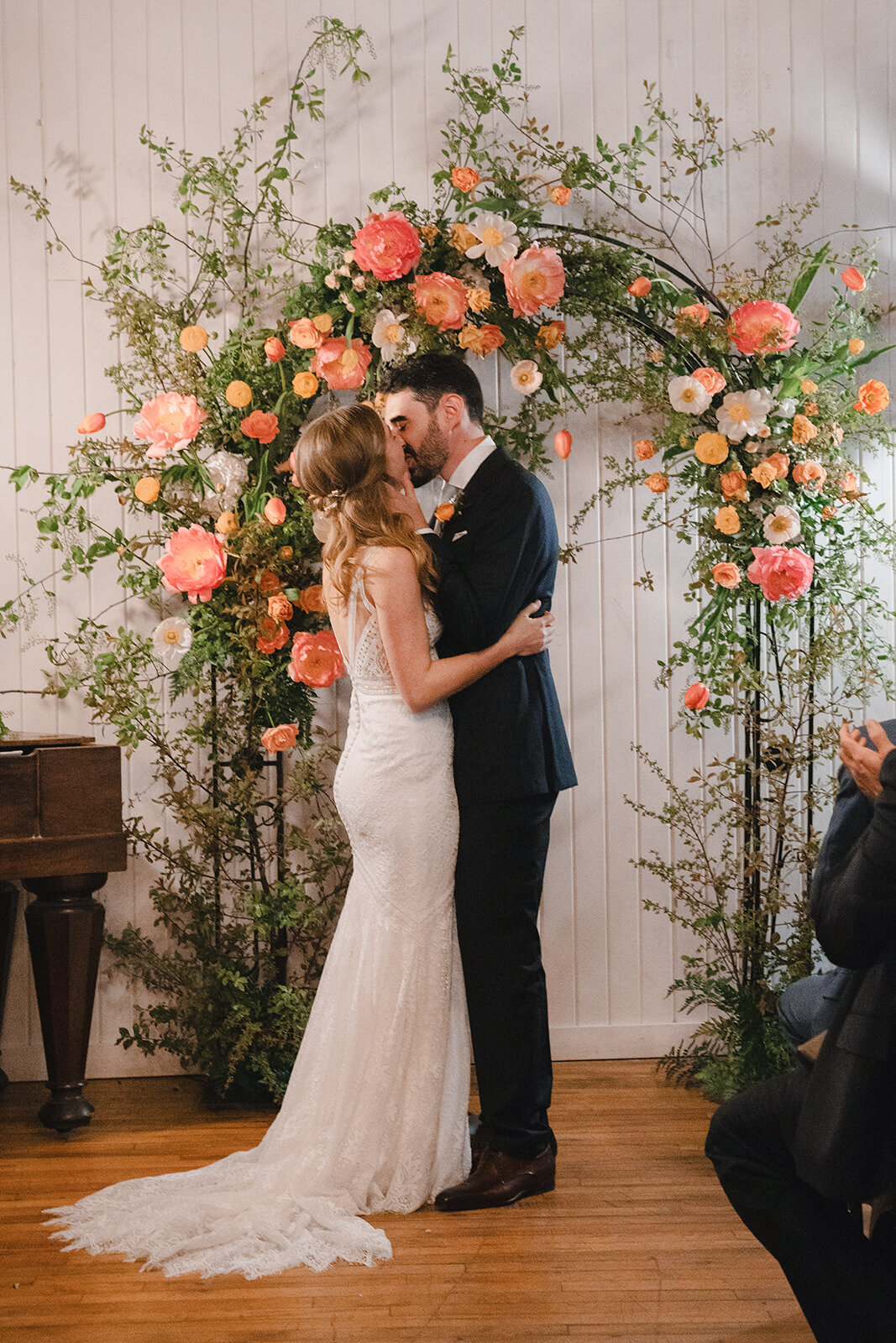 An elaborate arch of bright, pastel flowers for a wedding ceremony at Auberge St-Gabriel.