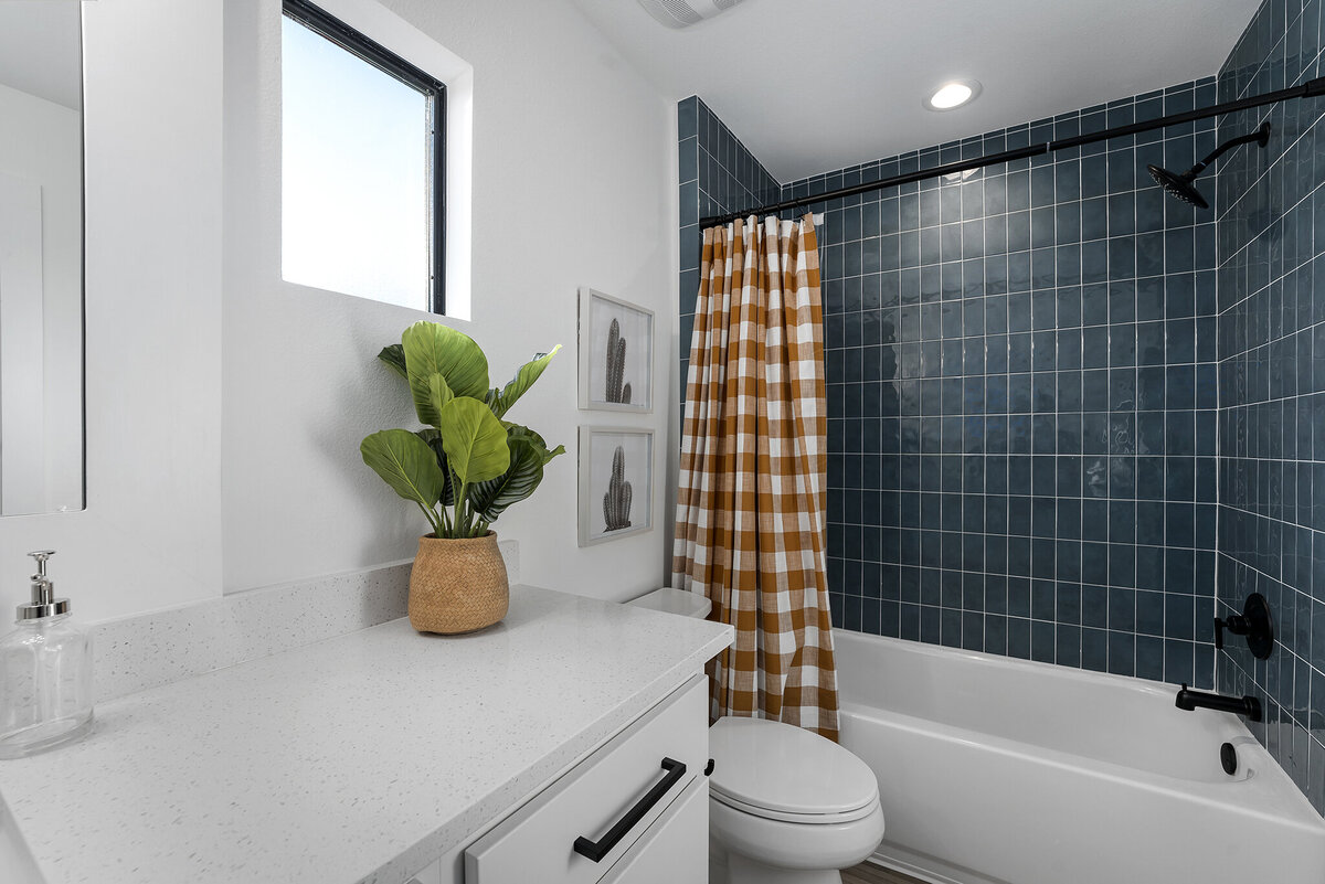 blue tile bathroom with gingham pattern shower curtain