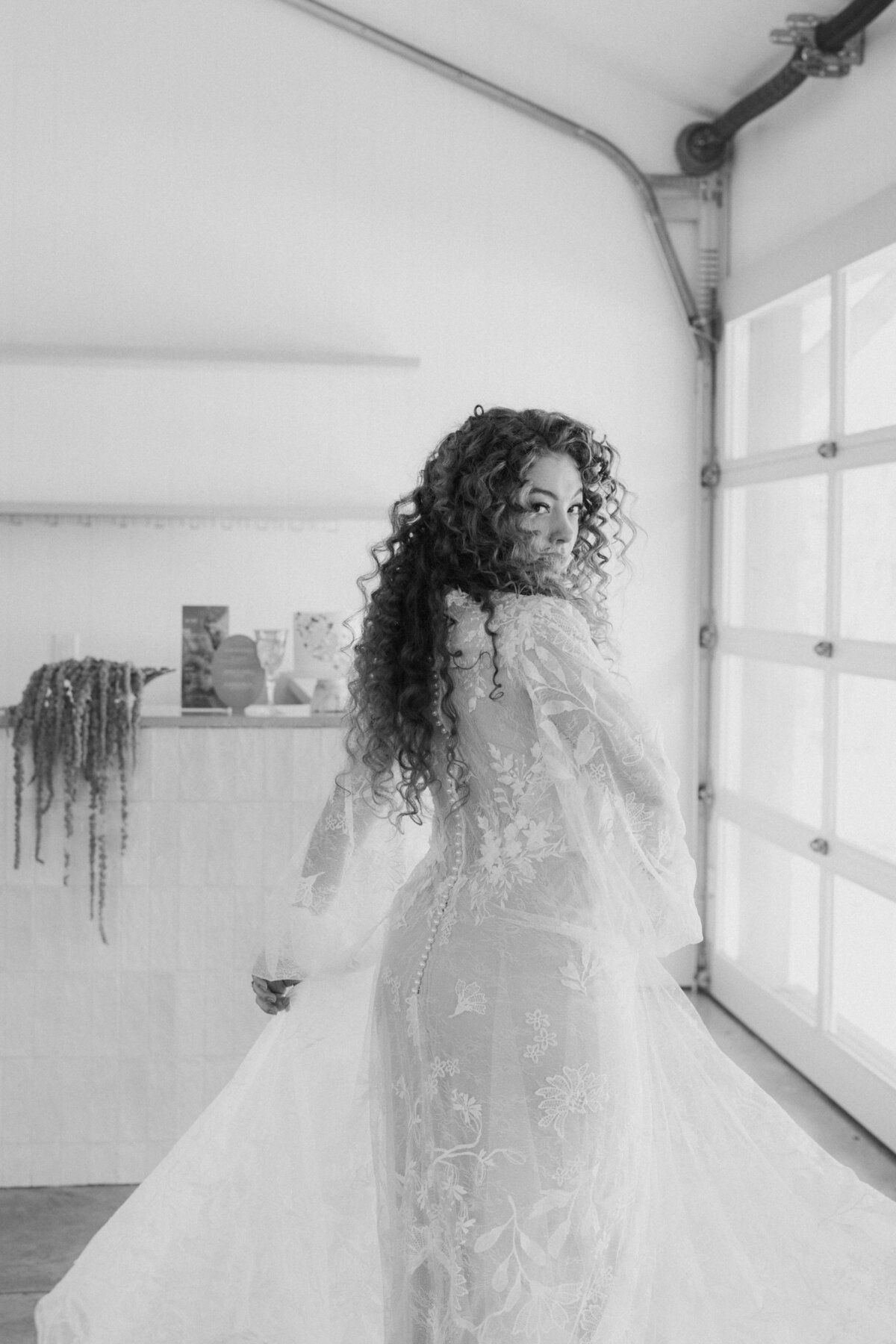 An over the shoulder shot of a bride playing with her wedding dress for a solo portrait