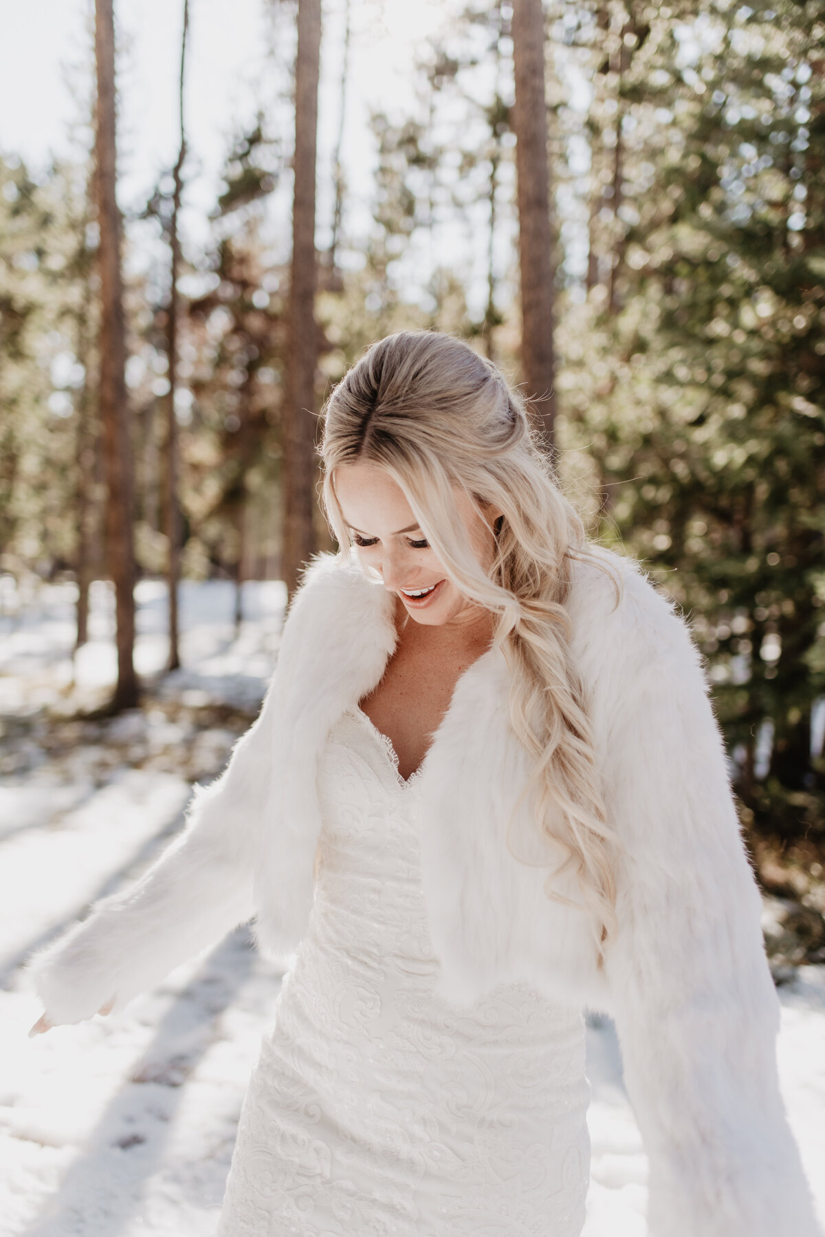 Jackson Hole Photographers capture bride wearing white furry jacket during bridal portraits after winter elopement