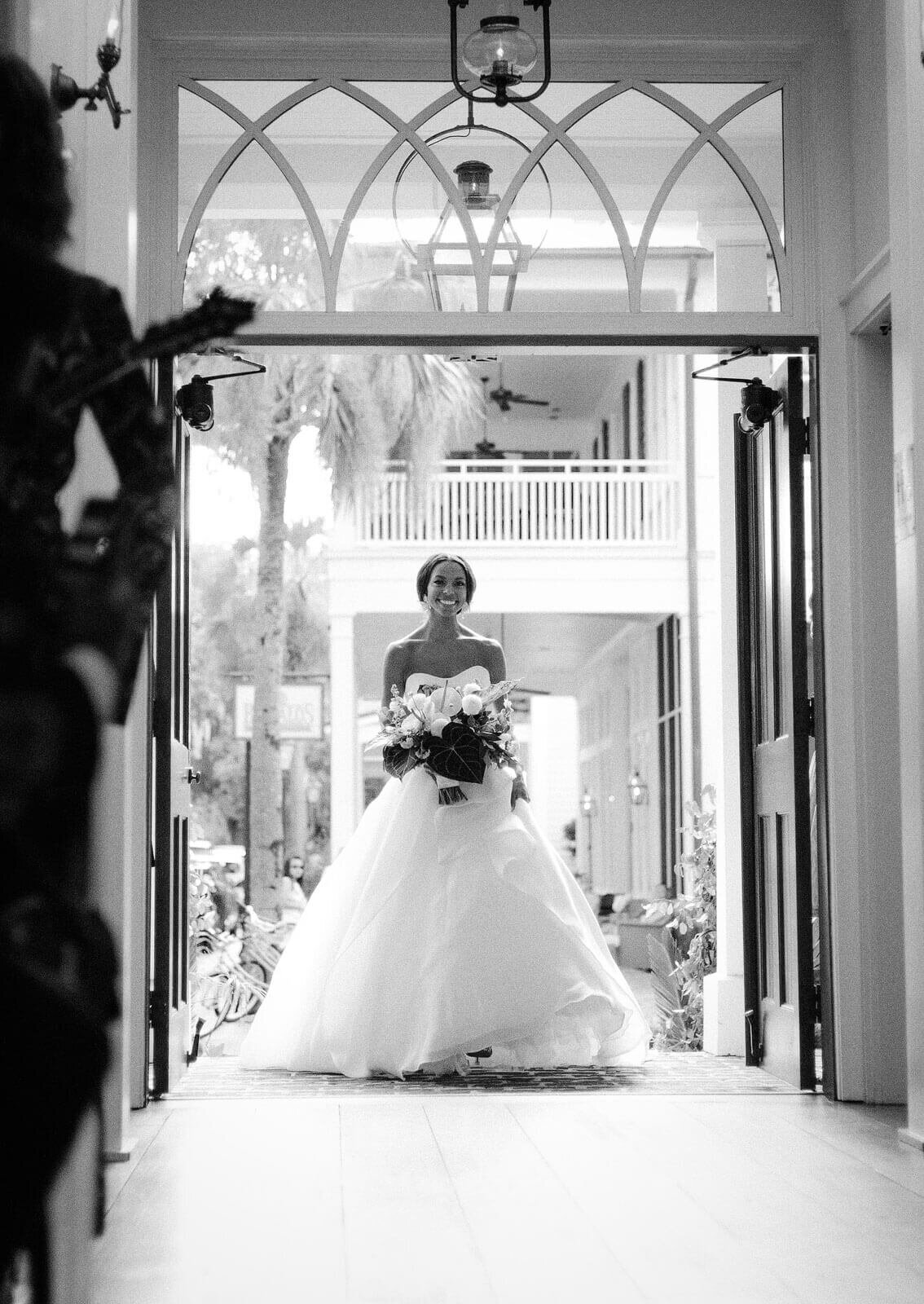 The smiling bride is walking towards the chapel entrance in Montage at Palmetto Bluff. Destination wedding image by Jenny Fu Studio