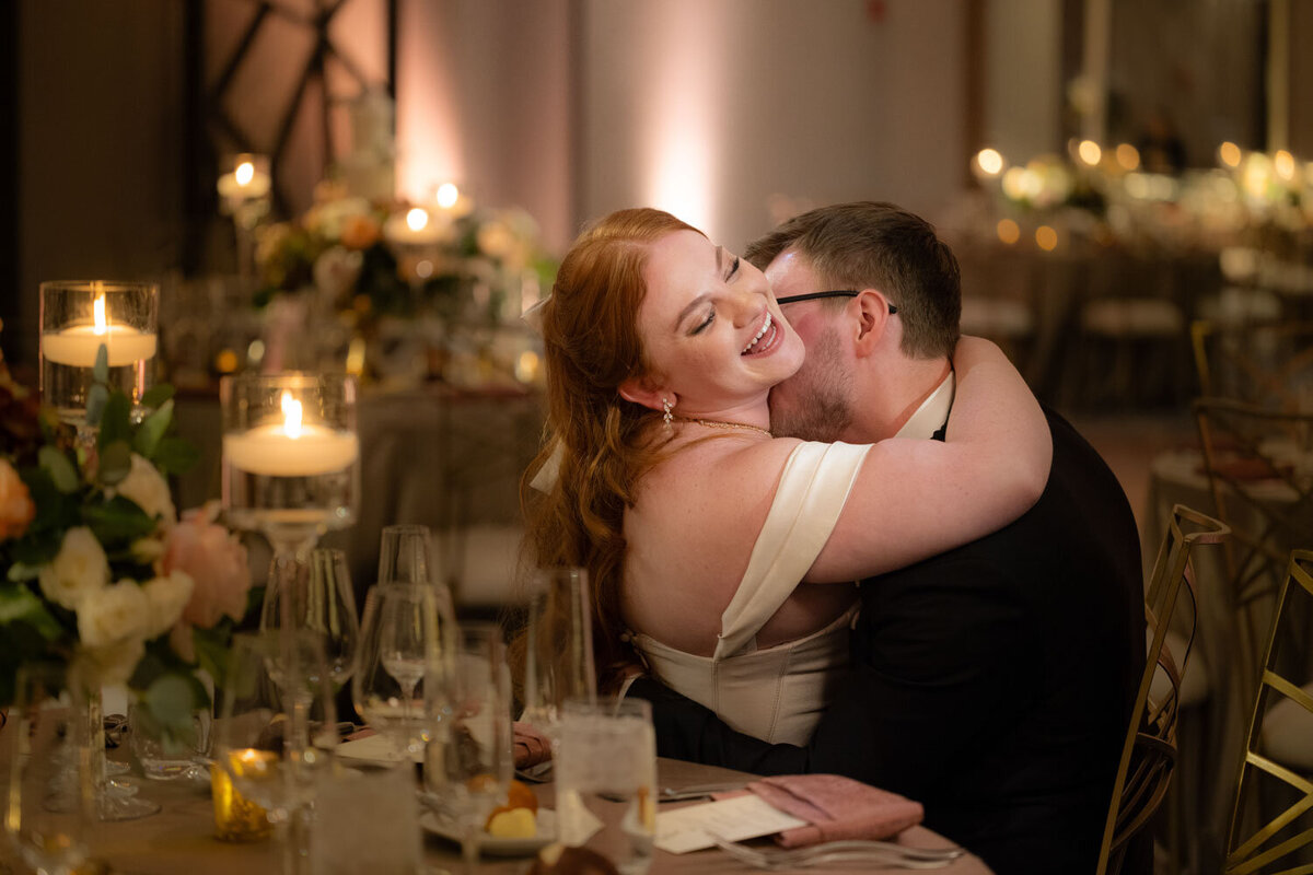 A man kissing a woman on the cheek at a wedding reception