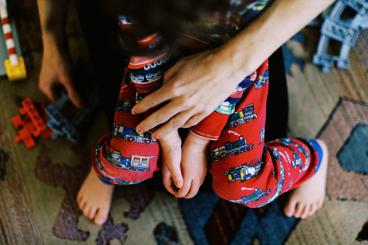 a son wearing pajamas sits on a mom's lap