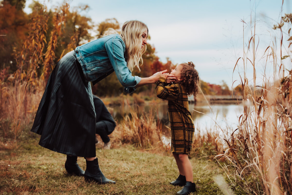 mommy banding over to talk to her baby, gently touching her face