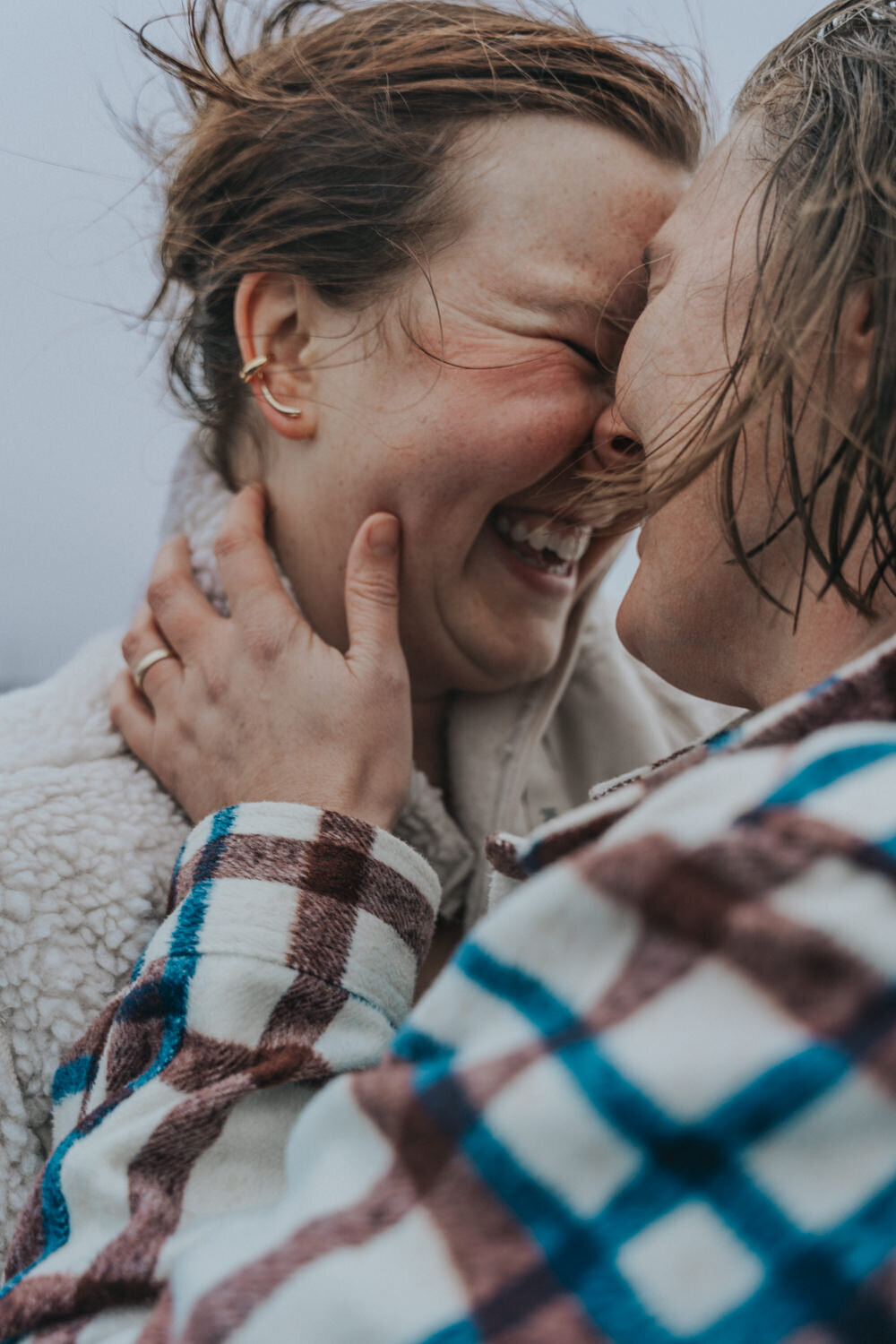 Two lesbian women embrace and stand nose to nose 