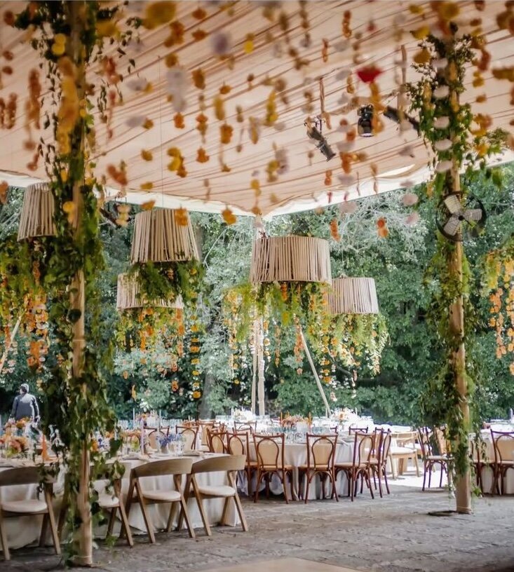 Garden wedding setup with vine-wrapped poles and hanging lamps, styled as inspiration for a lush reception at Airlie Gardens