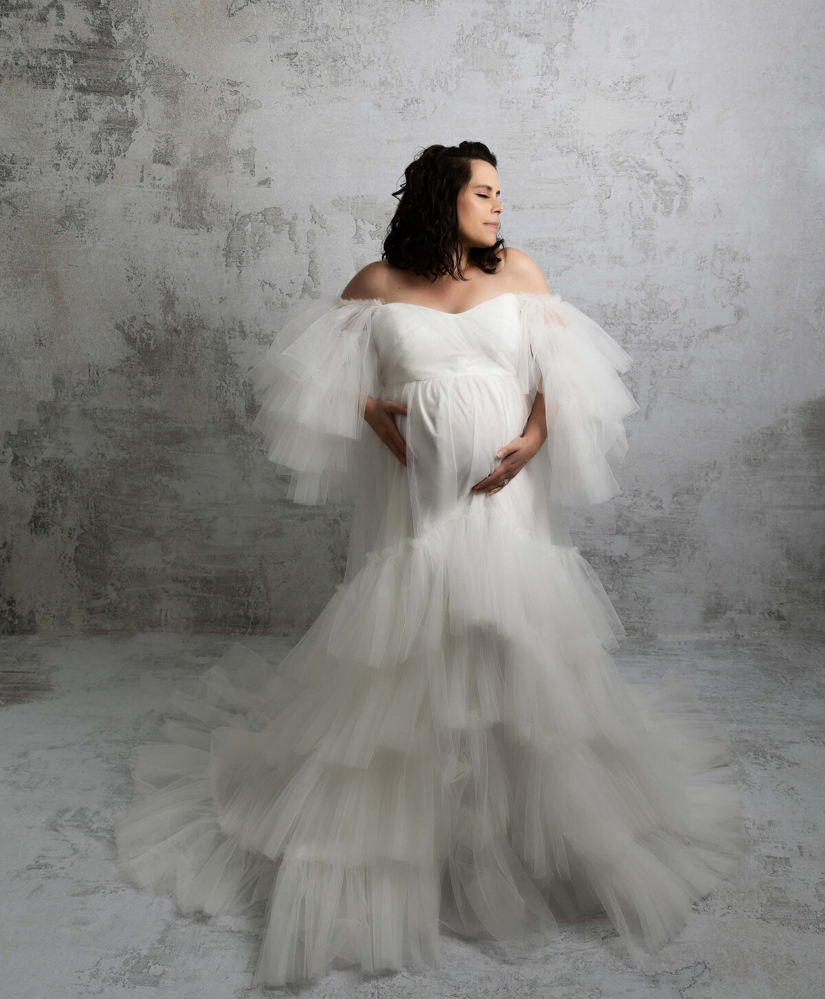 Maternity photo of a mother in a white gown in an erie pa studio