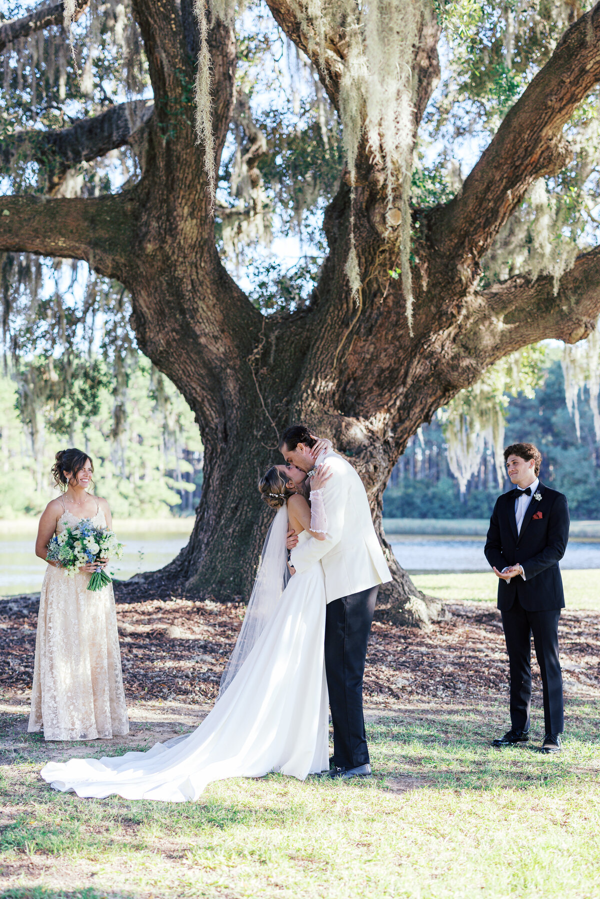 Bride and groom kiss in front of live oak with spanish moss in Charleston South Carolina