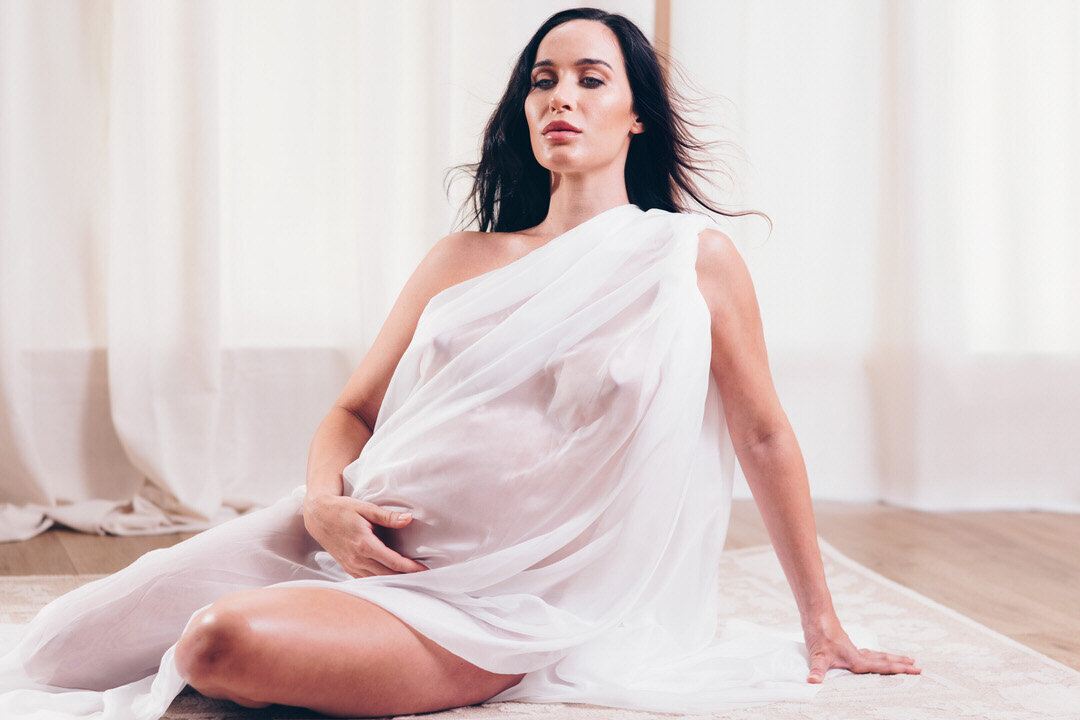 Maternity portrait with flowing hair in shear fabric