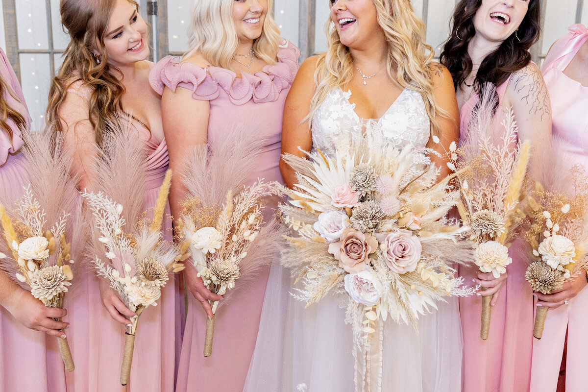 A detailed view of the bride and bridesmaids’ dried floral bouquets, featuring soft pink roses and natural textures.