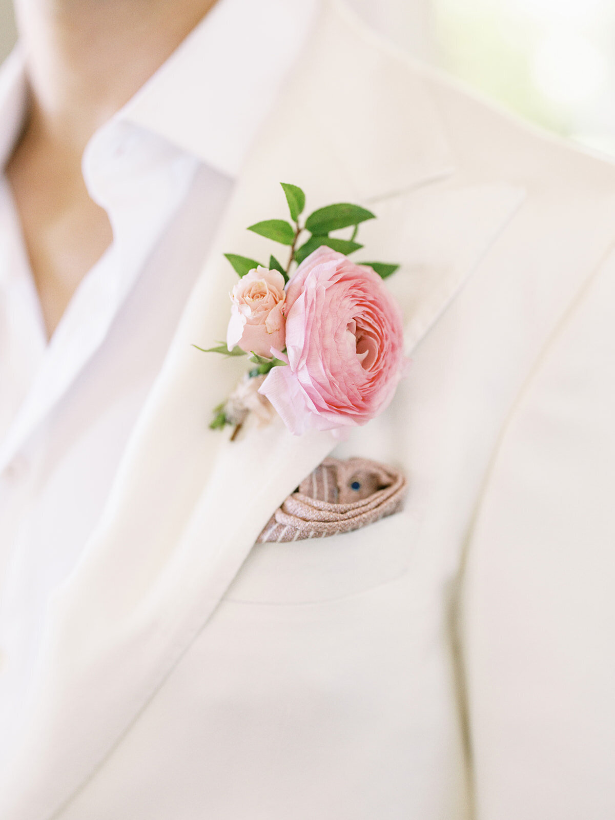 Dainty pink ranunculus boutonniere for spring beach wedding at private estate. Destination wedding in Exuma, Bahamas. Destination floral design by Rosemary & Finch Floral Design.