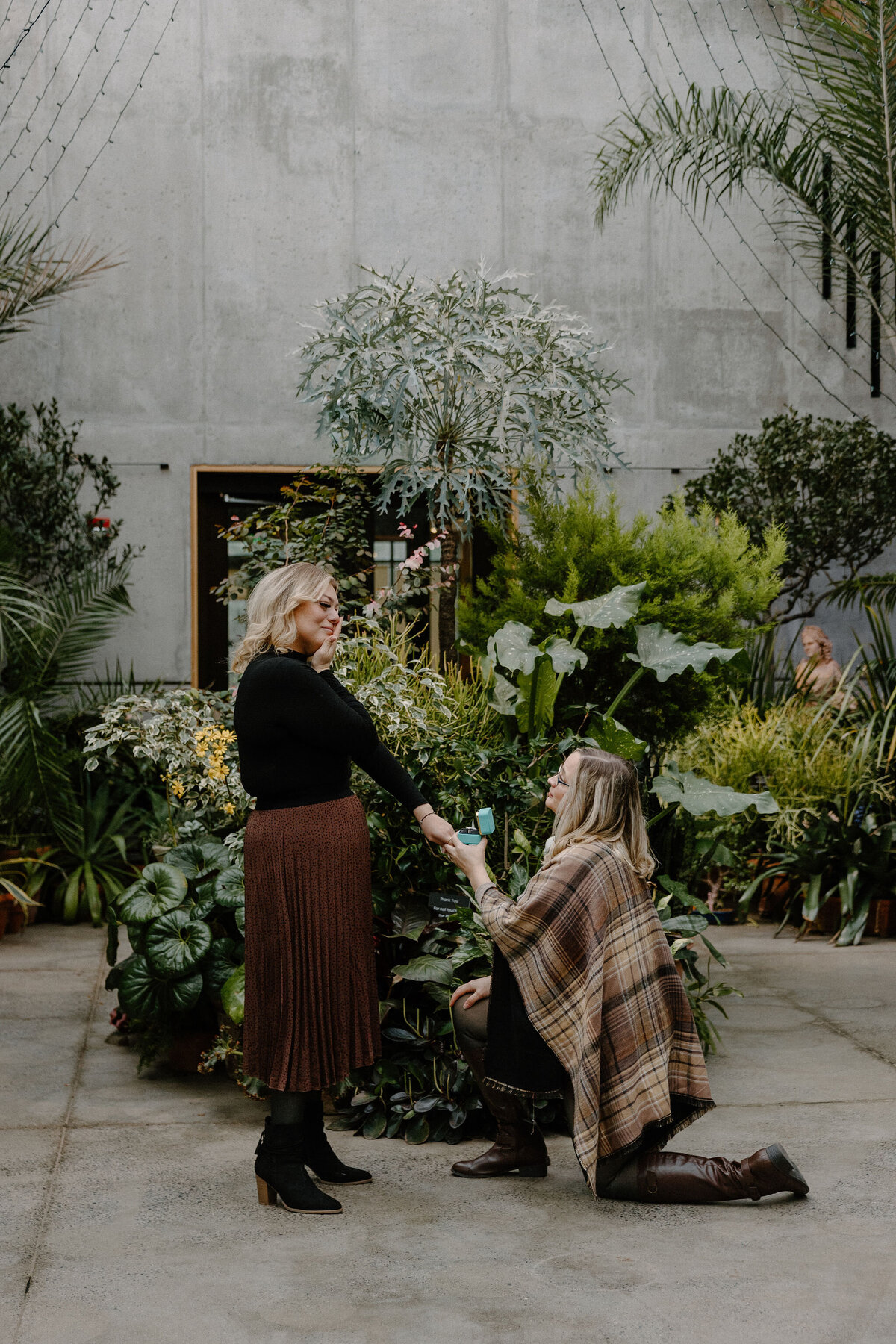 woman proposing to woman in indoor garden
