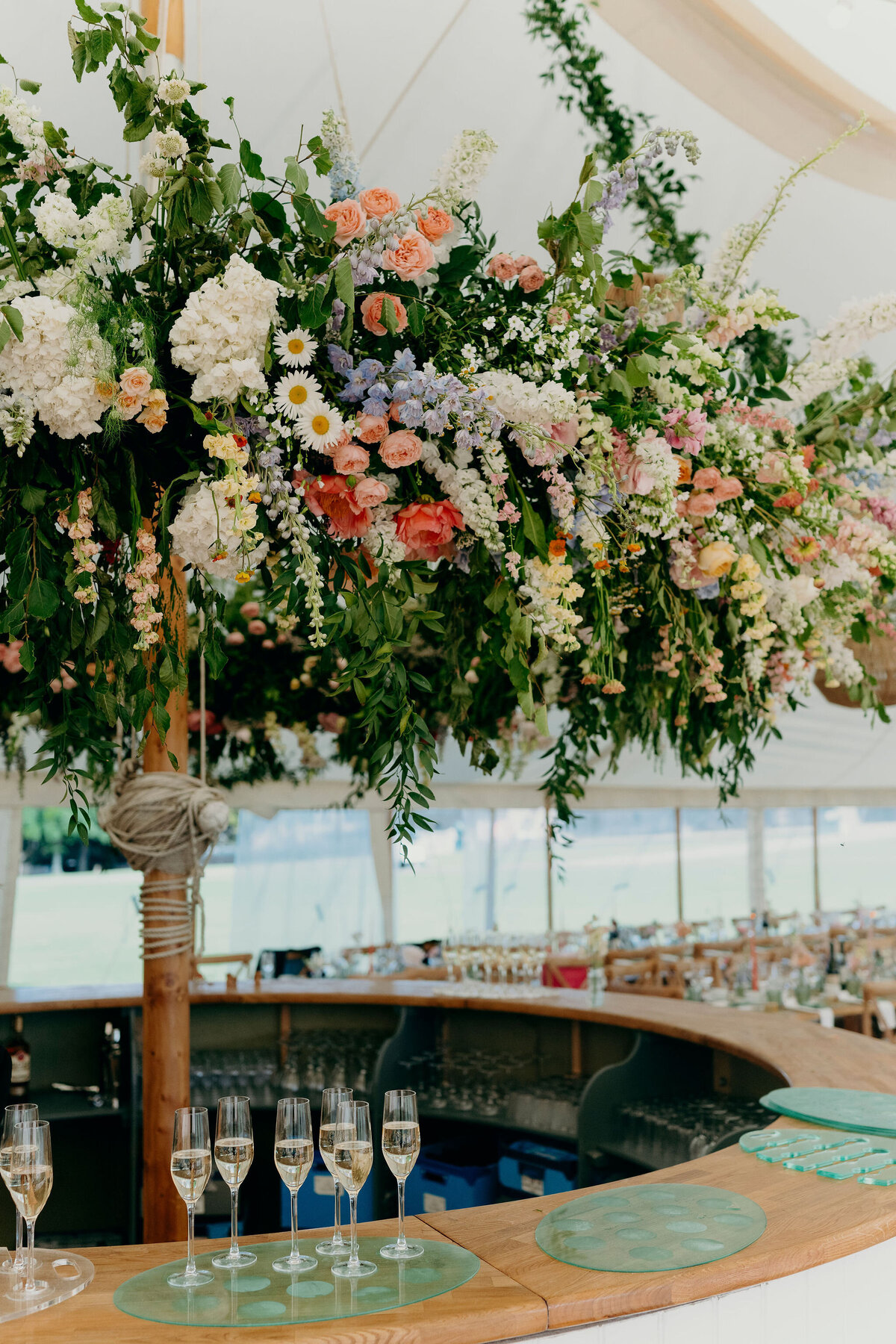 Floral hoop above a round bar hanging installation sailcloth reception