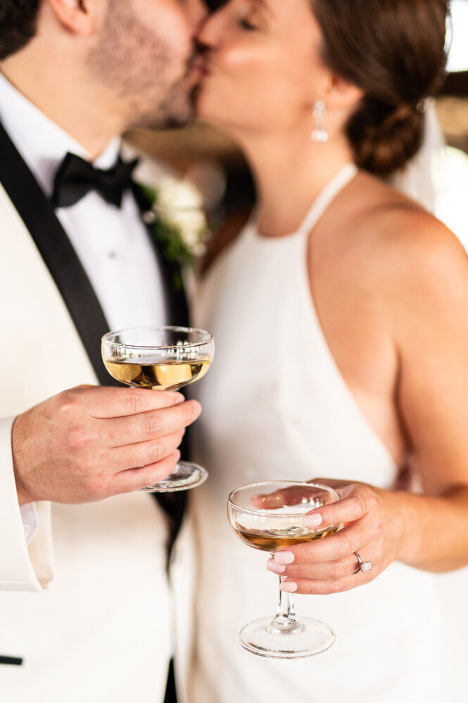 Bride and groom kissing with champagne glasses