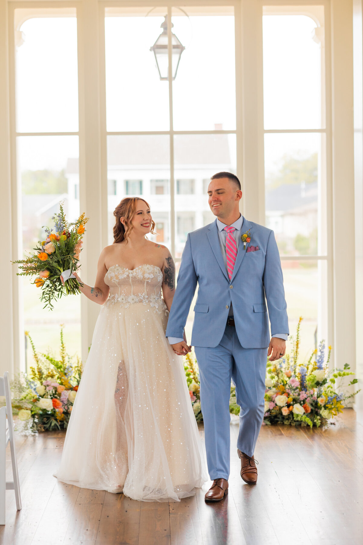 bride and groom holding hands with bouquet in hand at town hall in Columbus Georgia by Columbus Georgia elopement photographer Amanda Richardson Photography