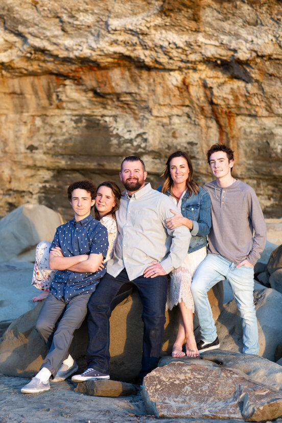 family-of-five-sitting-on-rocks-la-jolla-beach-san-diego