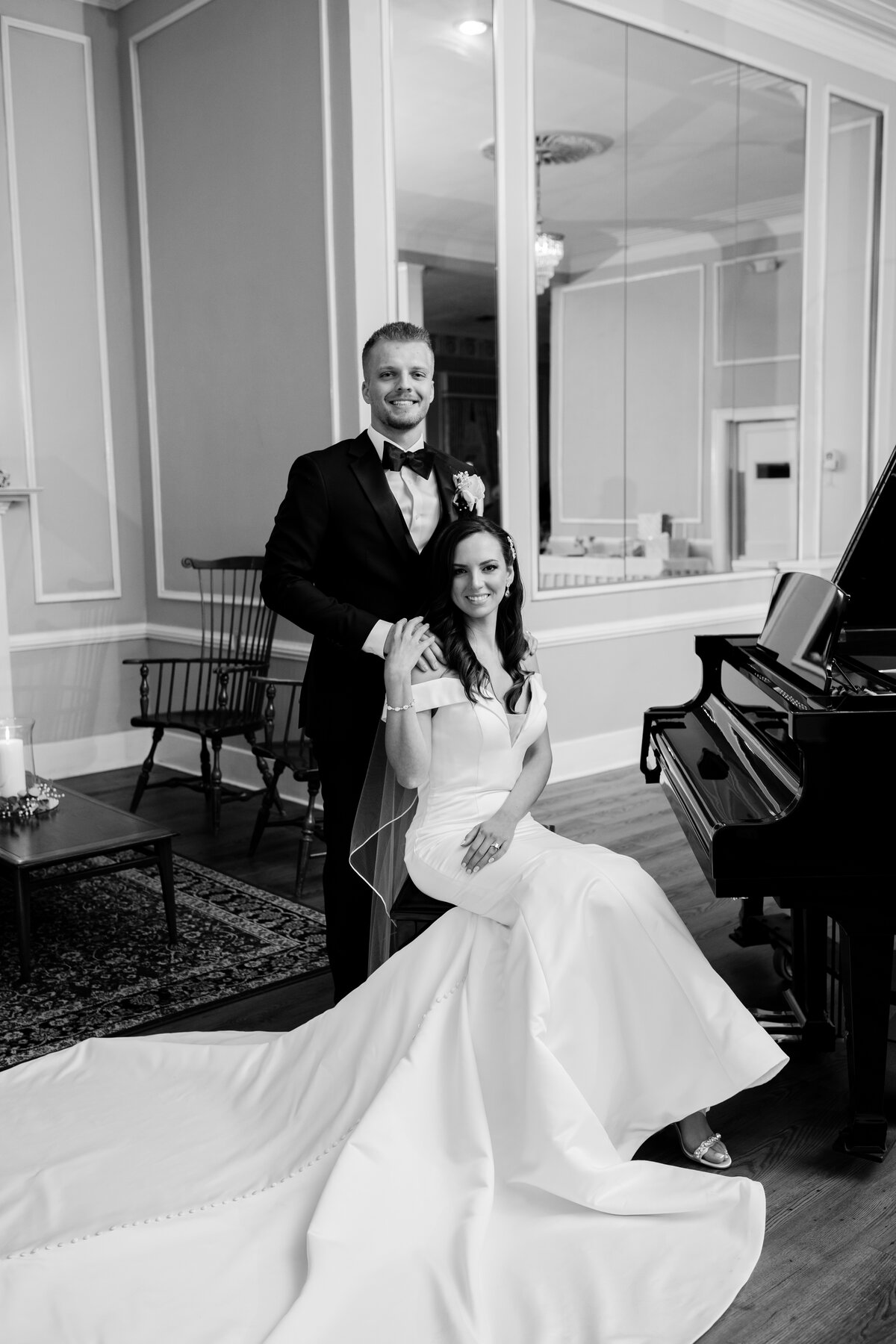 bride and groom sitting on a bench next to a piano