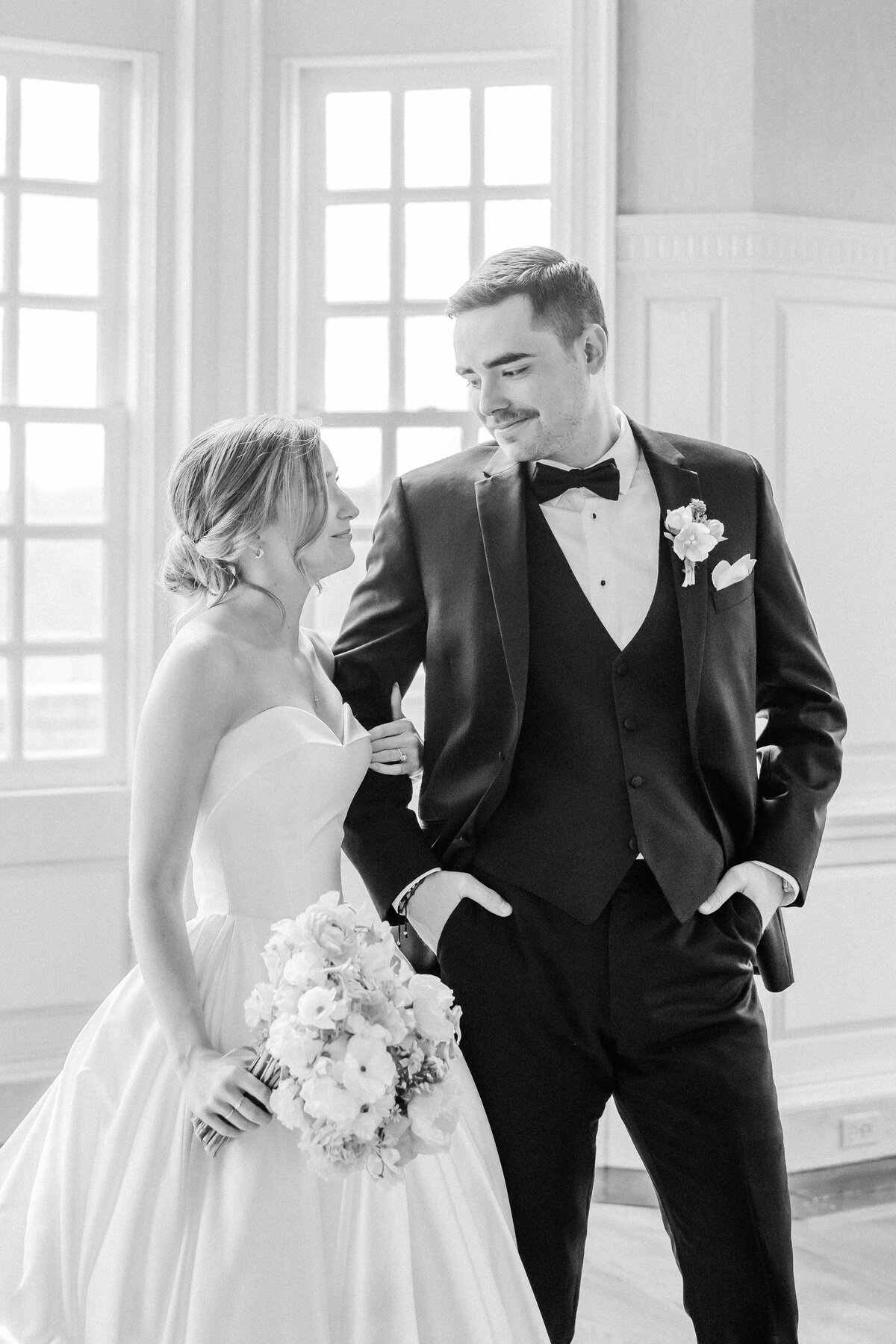 Bride and groom smiling at each other during portraits at the estate at river run in black and white