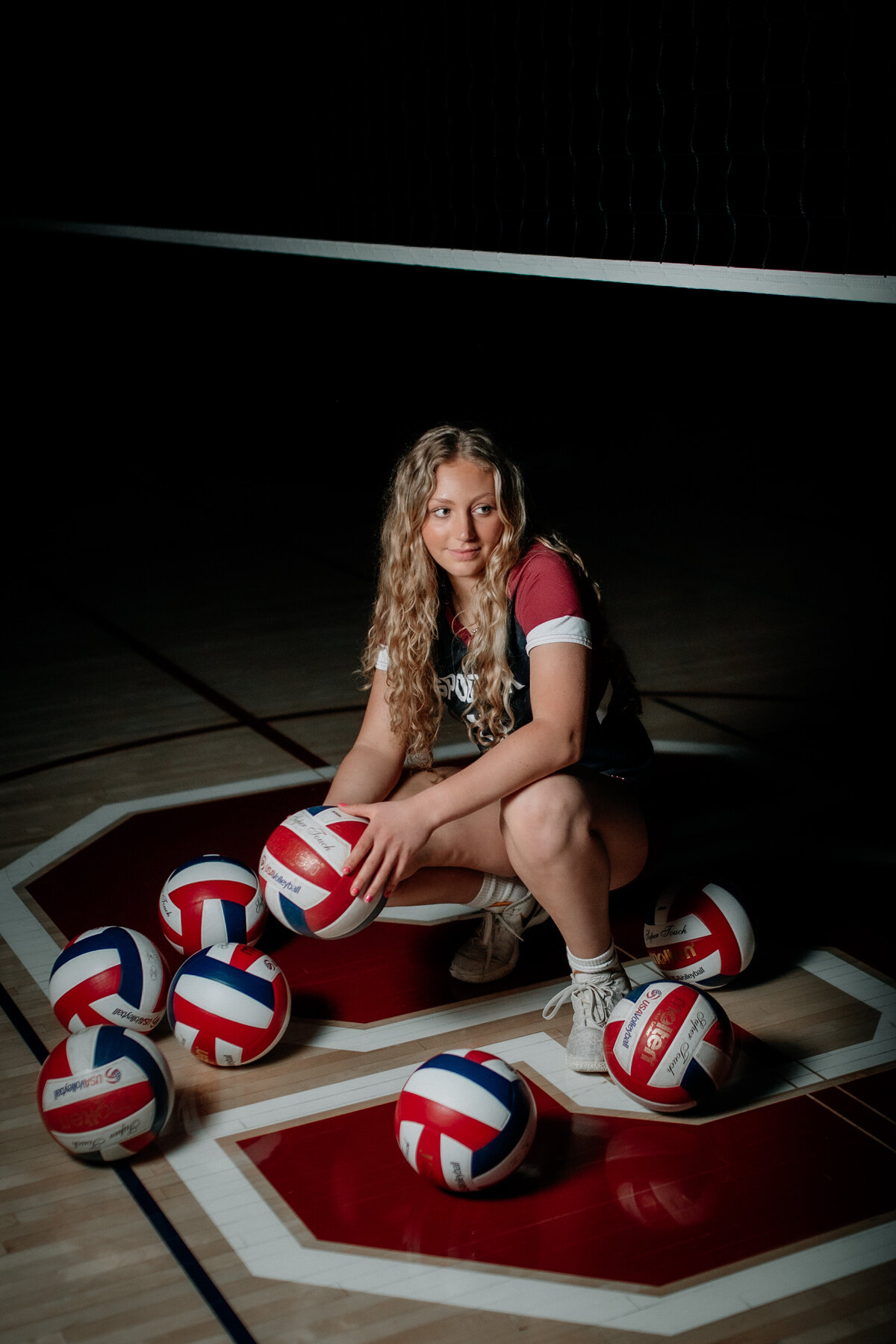 Moody volleyball senior pictures in a high school gym beneath a volleyball net.
