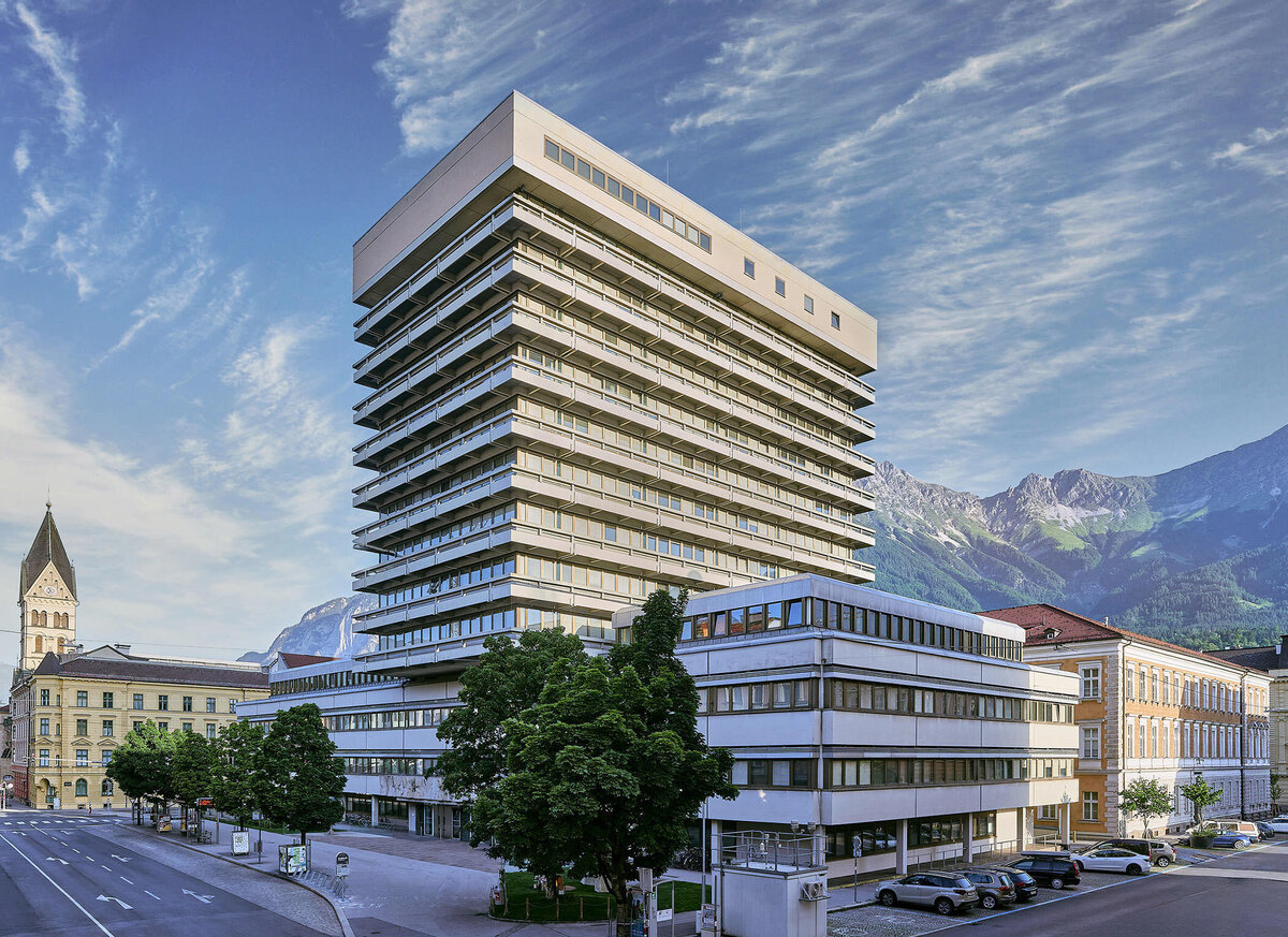 Modernes Bürohochhaus vor alpiner Kulisse in Tirol – Architekturfotografie mit Fokus auf klare Linien, Struktur und urbane Integration in Österreich.