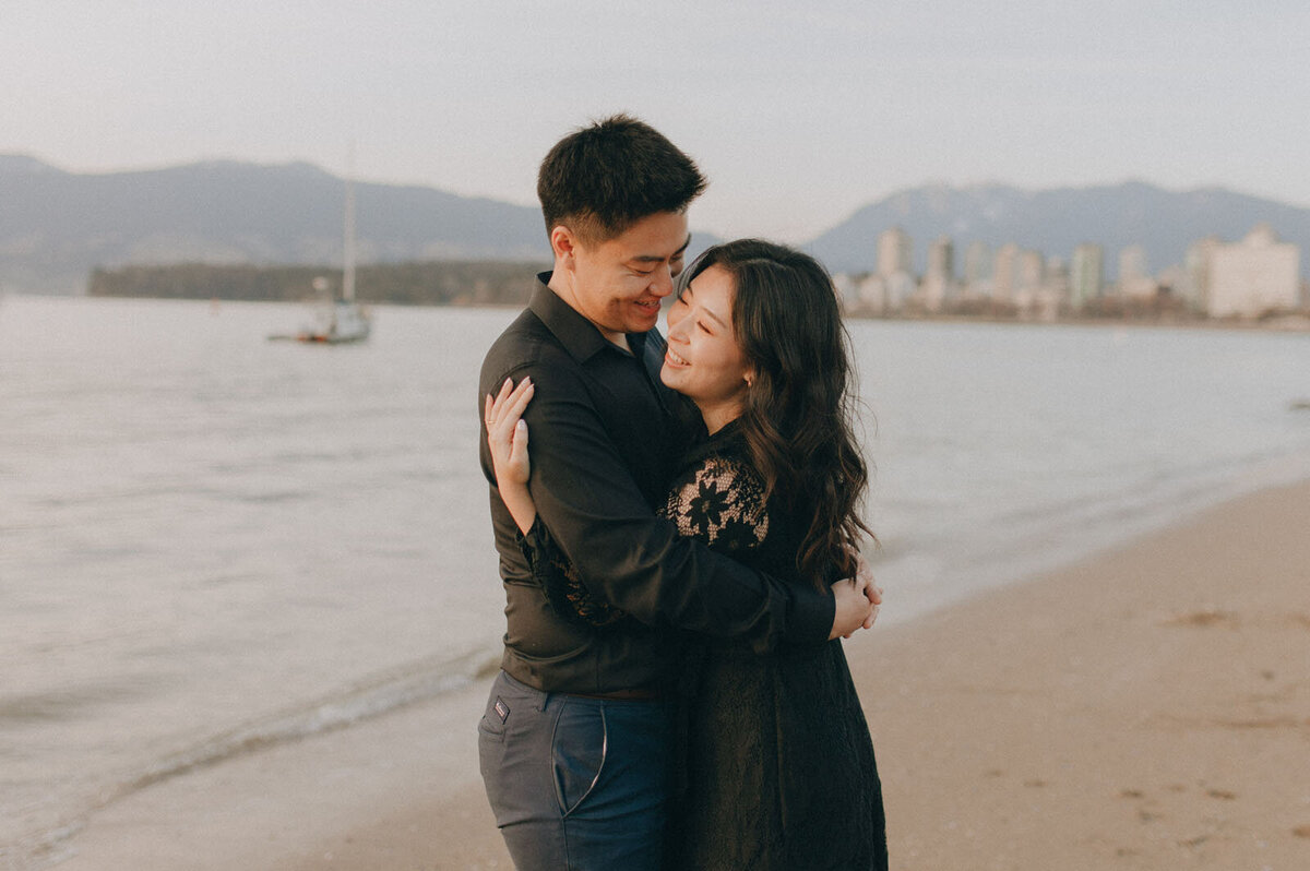 Couple hugging while the Vancouver Waterfront is behind them