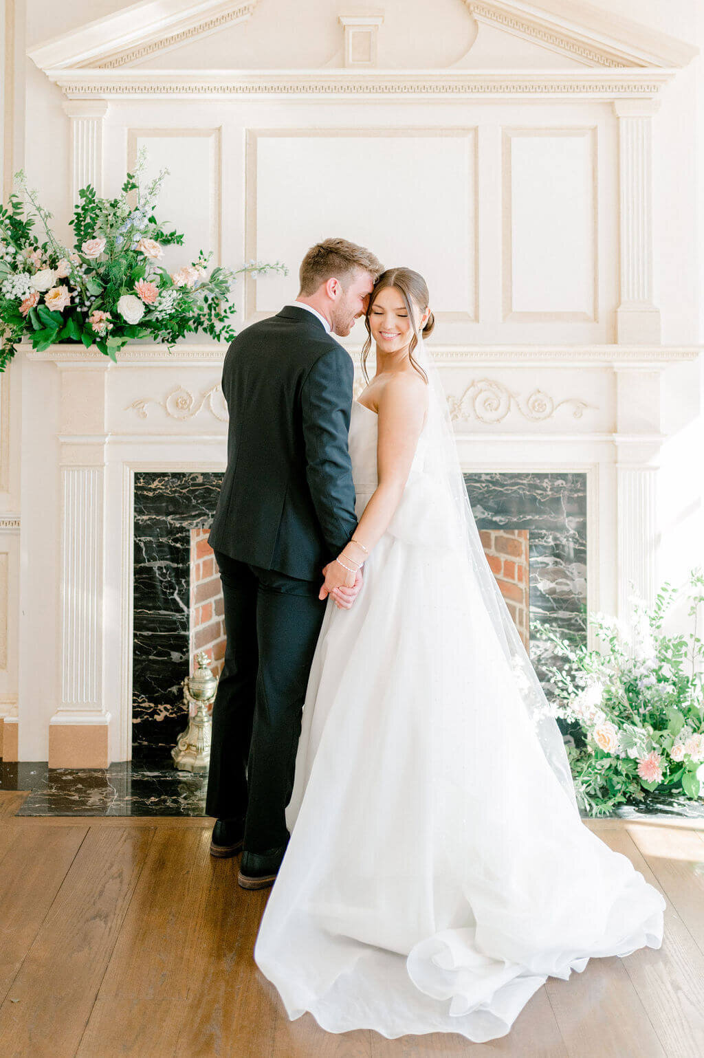 Couple nuzzling in front of fireplace for wedding photography