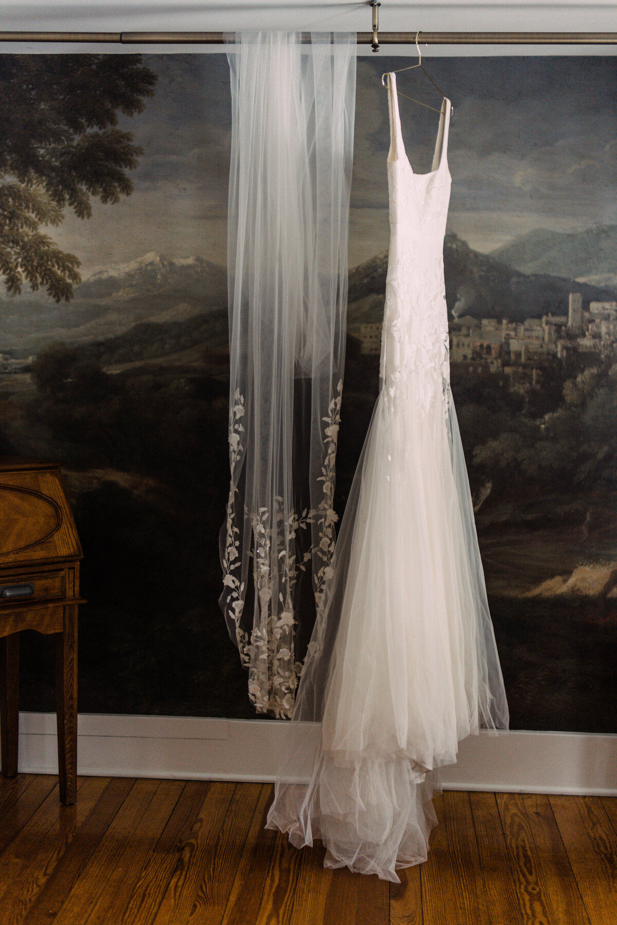 Alexandra Grecco Marcelle gown and Ainsley veil hanging in front of European fine-art mural at Zingerman's Cornman Farms