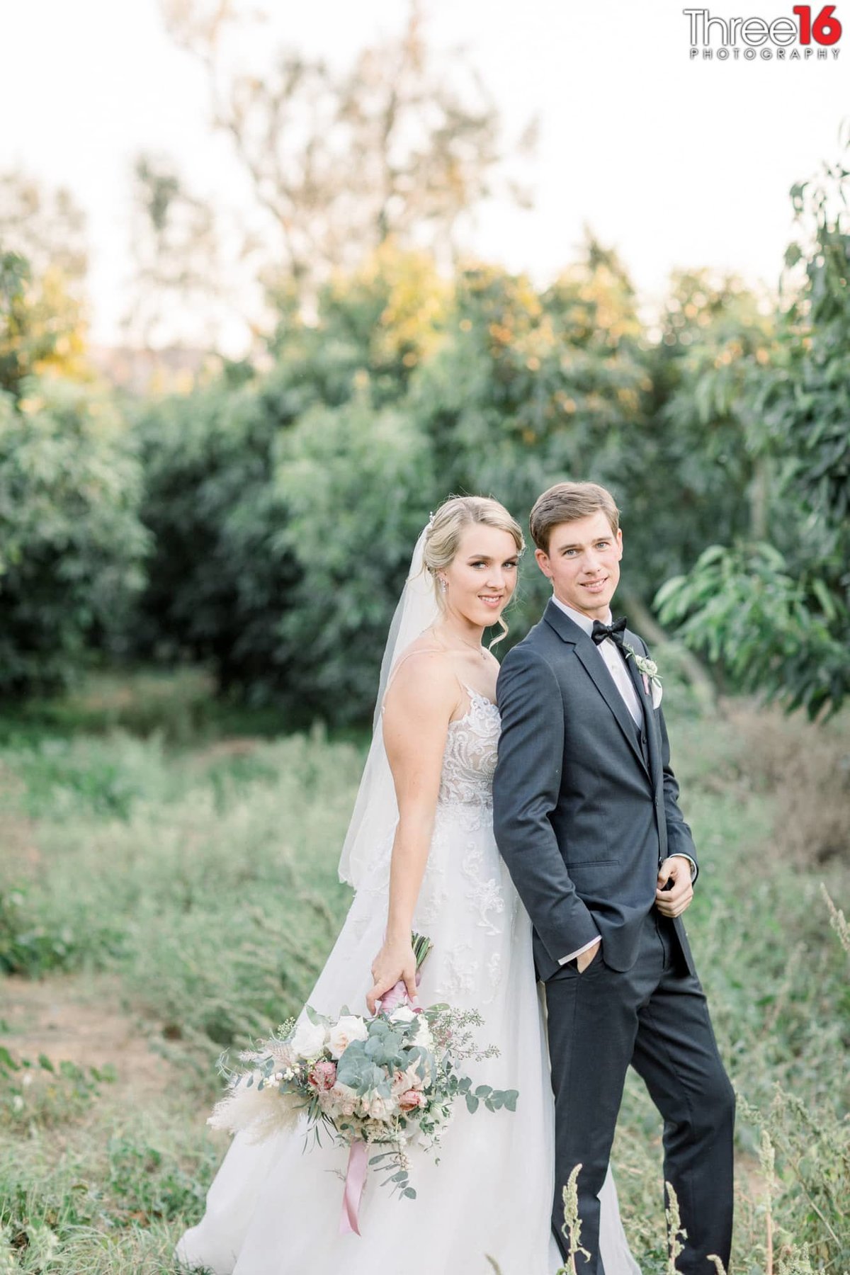 Bride and Groom pose together in the grassy field of Bella Vista Groves