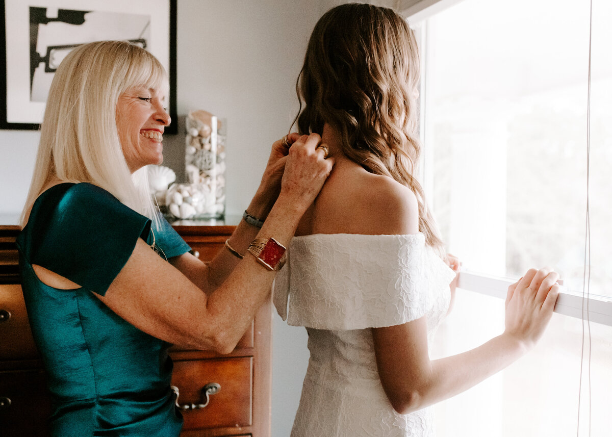 Mother helping her daughter get ready for her wedding