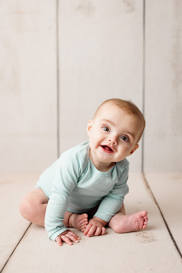 One year old boy sits for his session with Angela Marie Media.