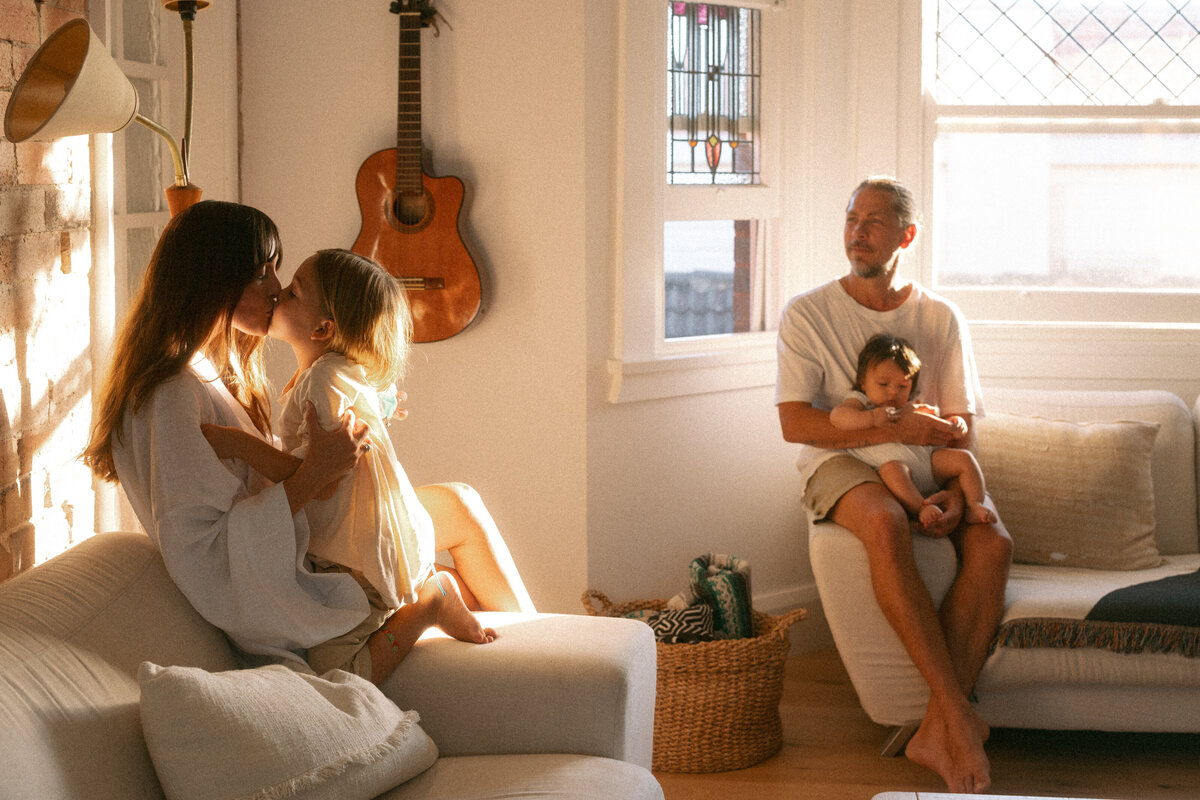 Family relaxing together in a sunlit living room, a natural family photoshoot in Sydney