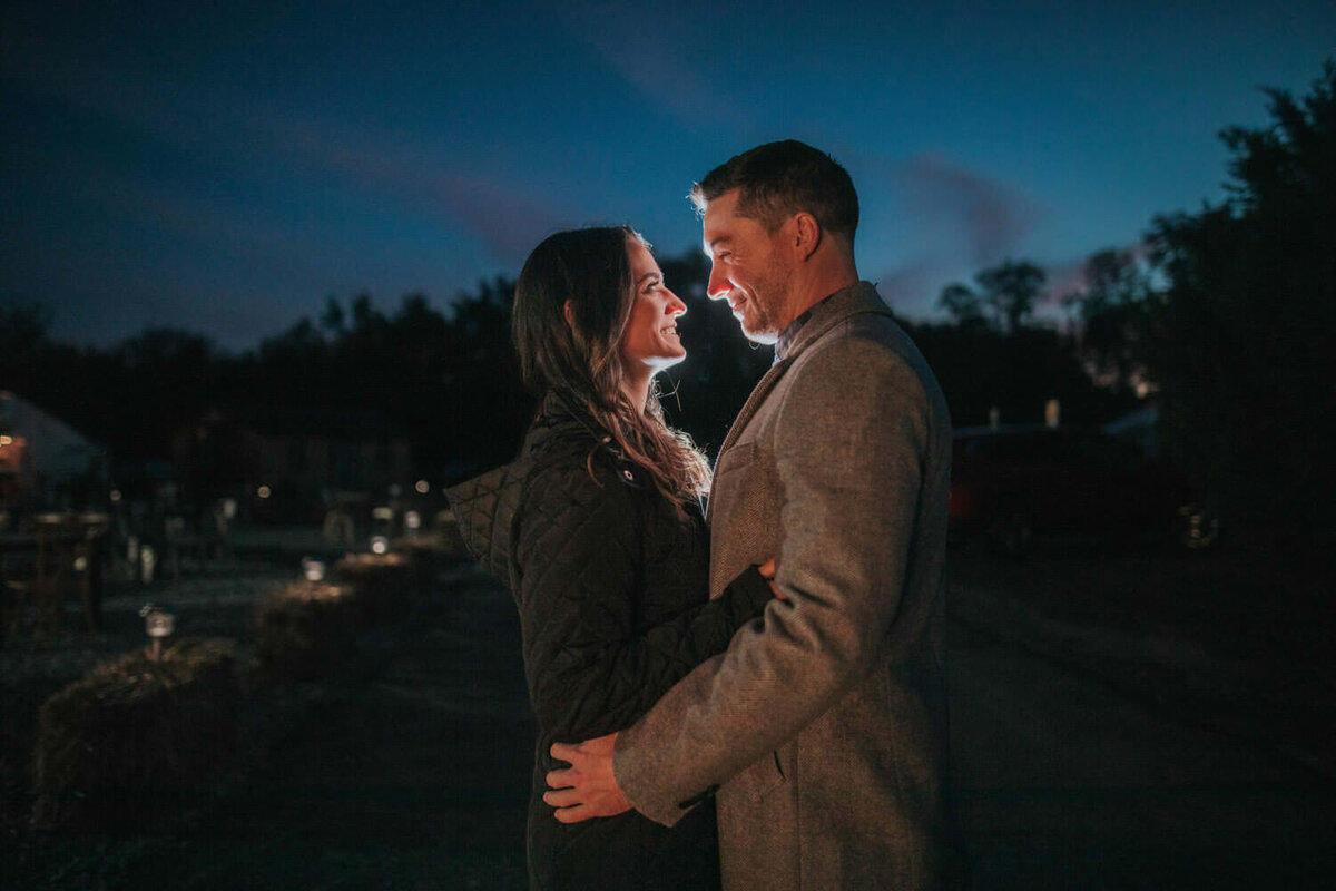A couple shares an intimate moment under a twilight sky at Cecil Creek Farm.