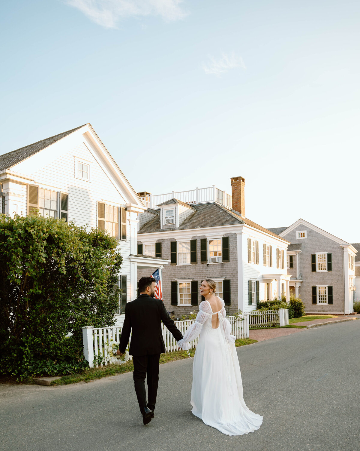 Couple holds hands in the street in Marthas Vineyard during golden hour