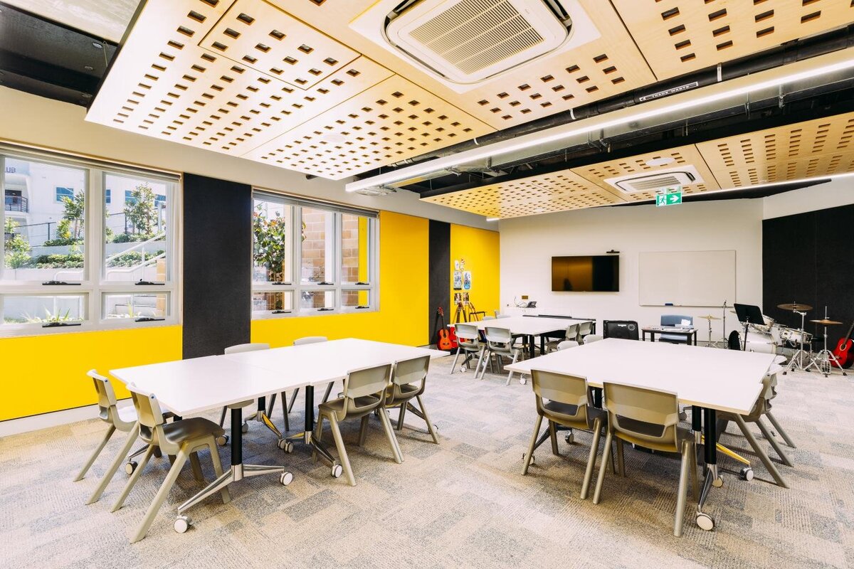 Modern classroom interior at Marist Catholic College South Hurstville, designed with wood-panel ceiling, flexible furniture layout, and large windows — project by Serlana.