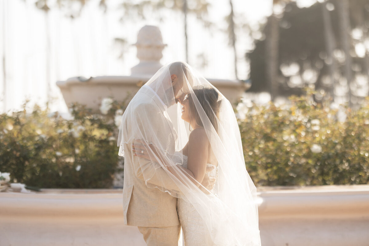Bride and groom under wedding veil at Hilton Beachfront Resort Santa Barbara