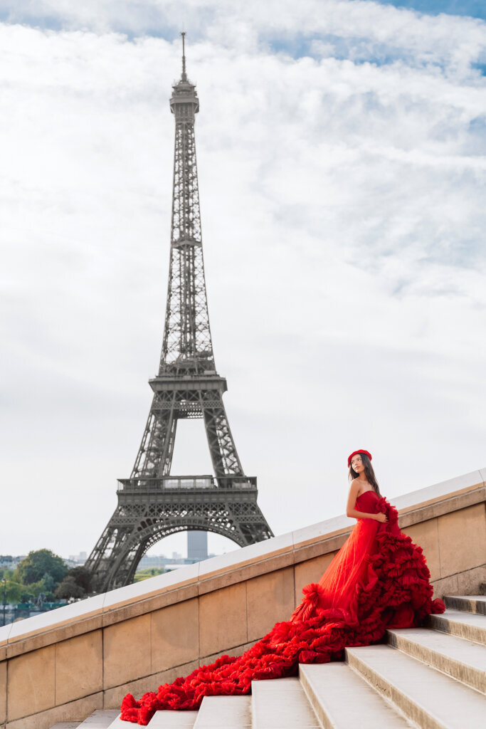 Romantic Paris portrait at Trocadero steps with woman in flowing red dress and beret cascading down stairs Eiffel Tower backdrop