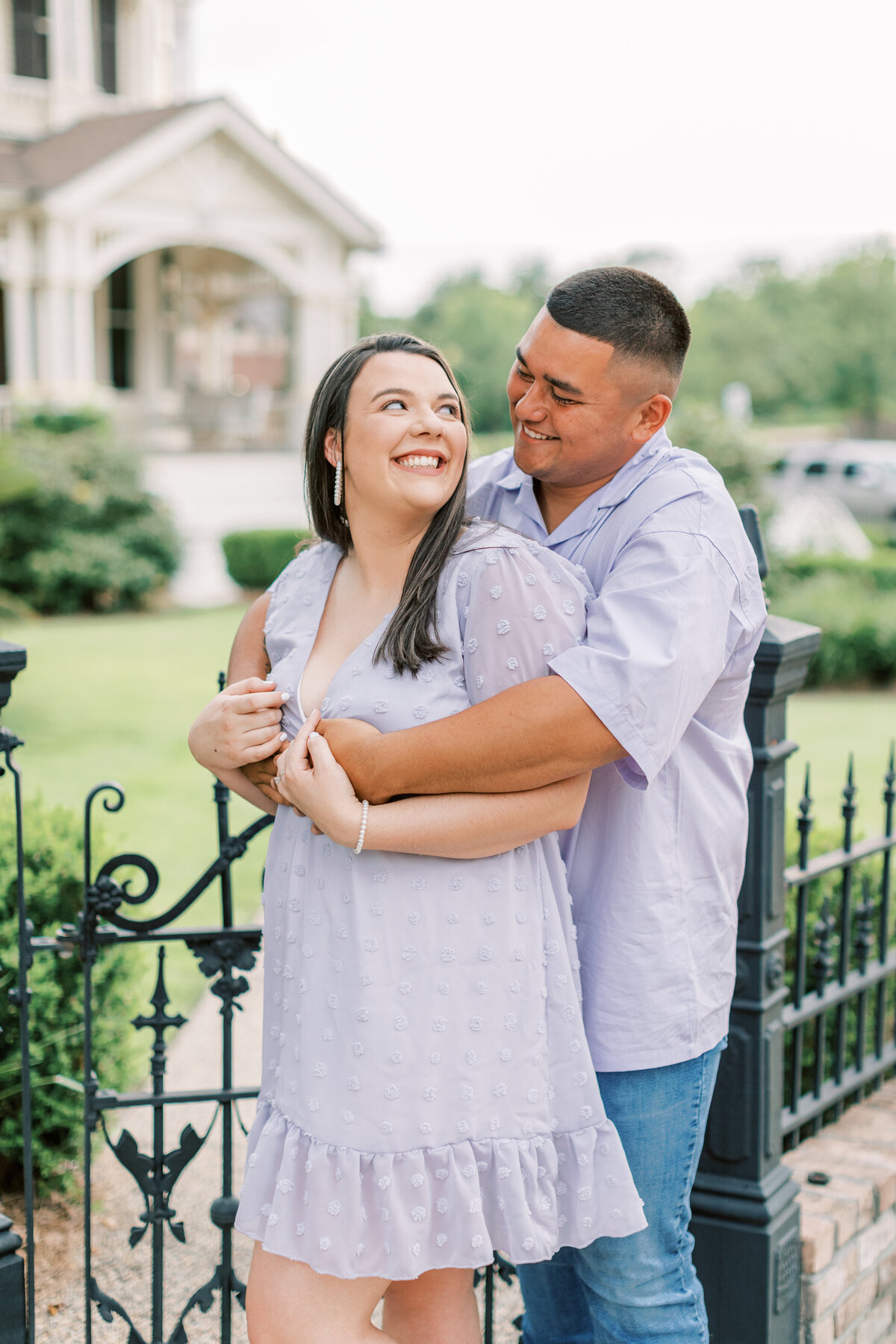 A couple embraces each other on the sidewalk.