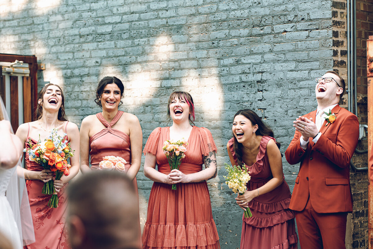The wedding party shares a laugh during vows at a ceremony at The Joinery in Chicago
