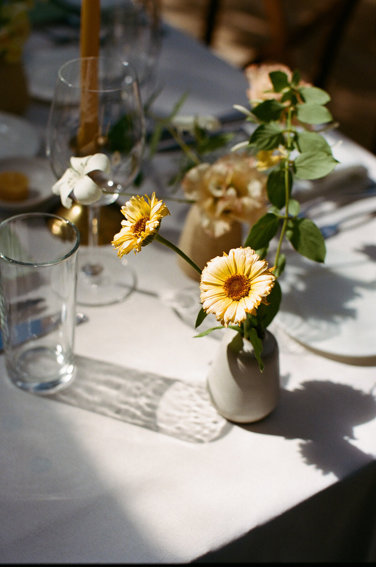 Ivory and yellow florals on a white linen table at wedding reception at Mattie's Austin