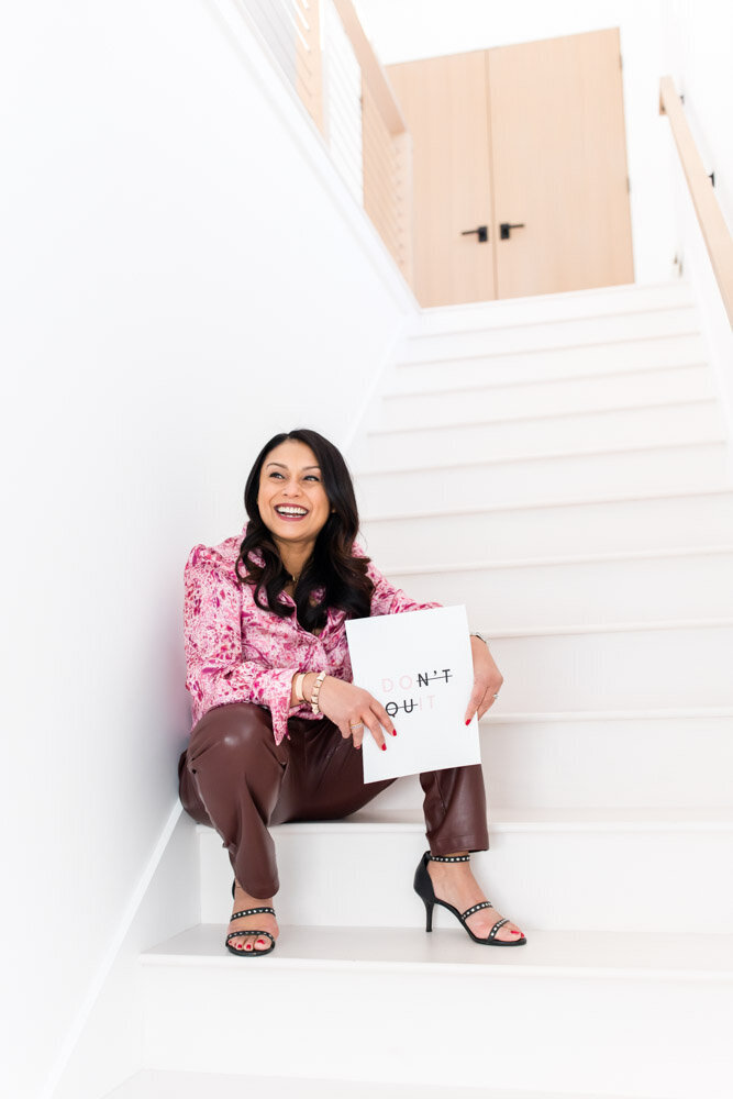 Female entrepreneur holding empowering sign on stairs
