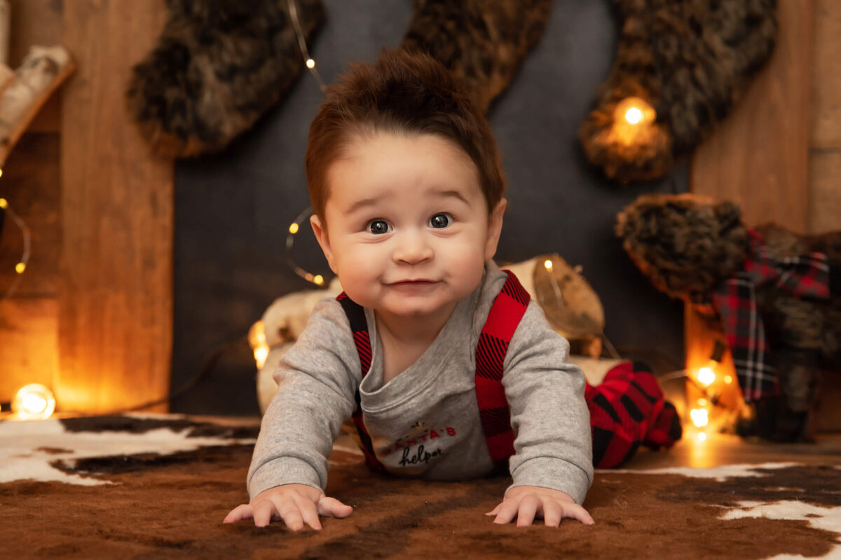 baby boy on his belly in front of a fireplace for his christmas kids family photos in Burlington, ON