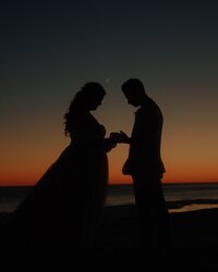 fallback shared on Invalid Date | a silhouette of a couple holding hands at the beach