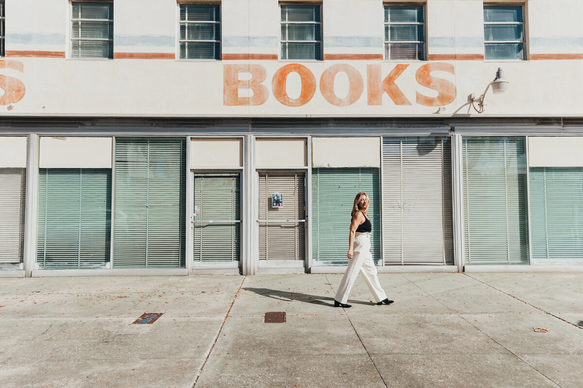 branding image of a woman walking in front of a bookstore