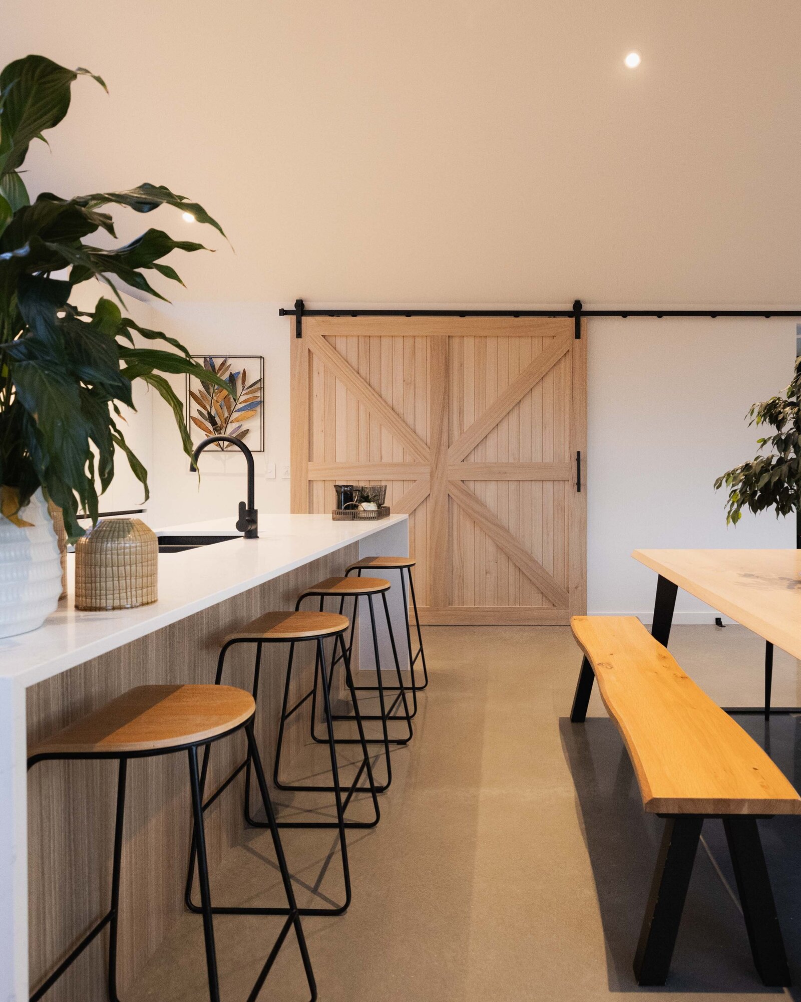 A feature sliding timber barn door in the kitchen dining area of a home built by Twin Peaks Construction in Hanleys Farm, Queenstown.