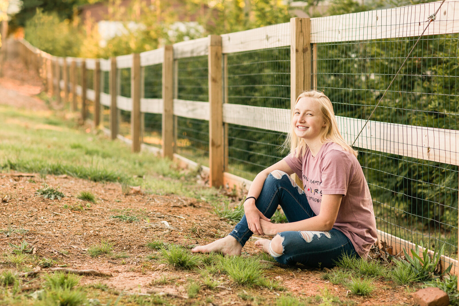 senior girl at a farm with a fence