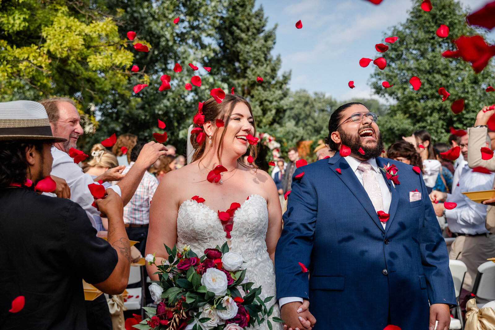 Bride and groom walking through rose pedals