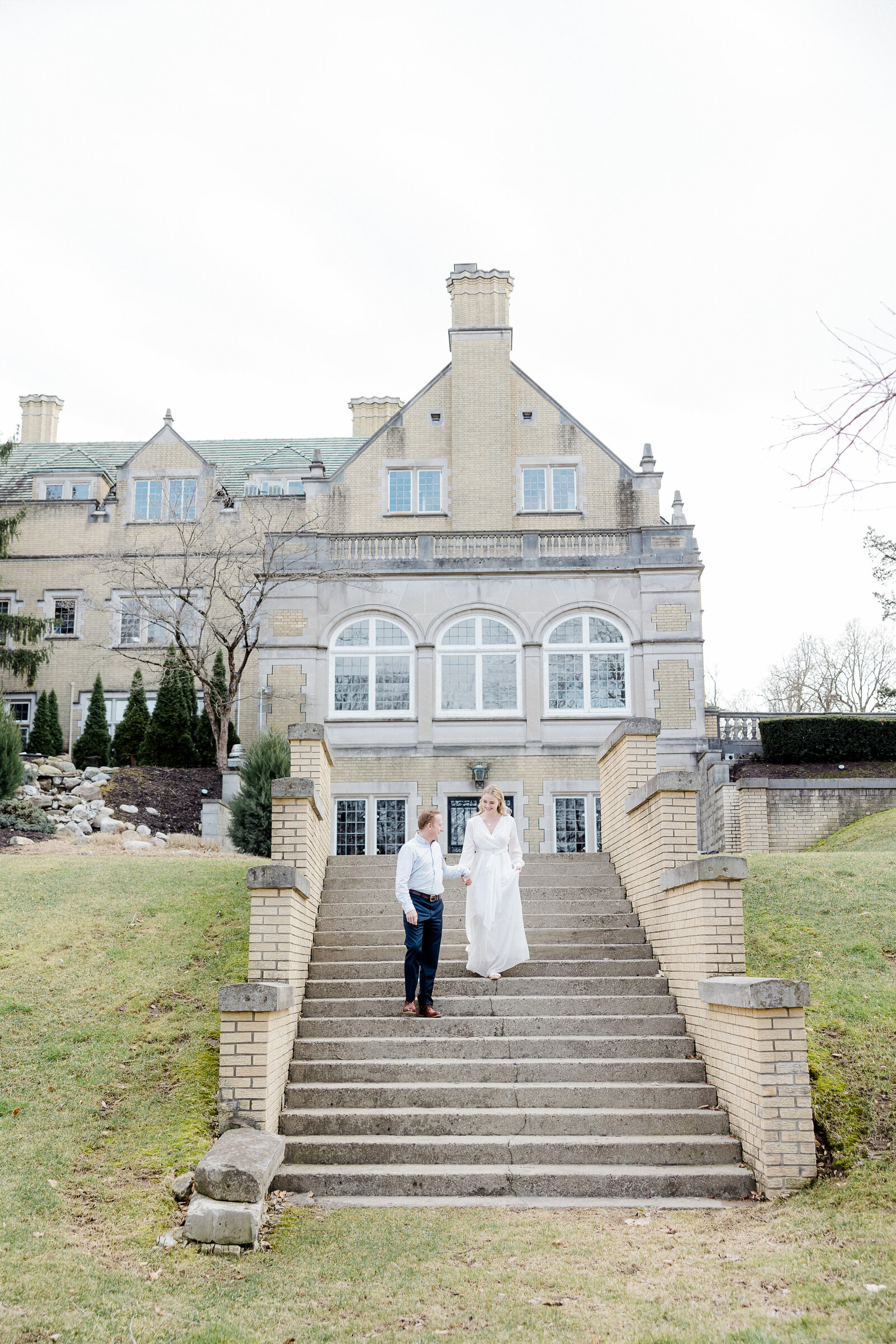 couple walking down stairs at Laurel Hall, photographed by Kaitlin Mendoza Photography, an Indianapolis engagement photographer