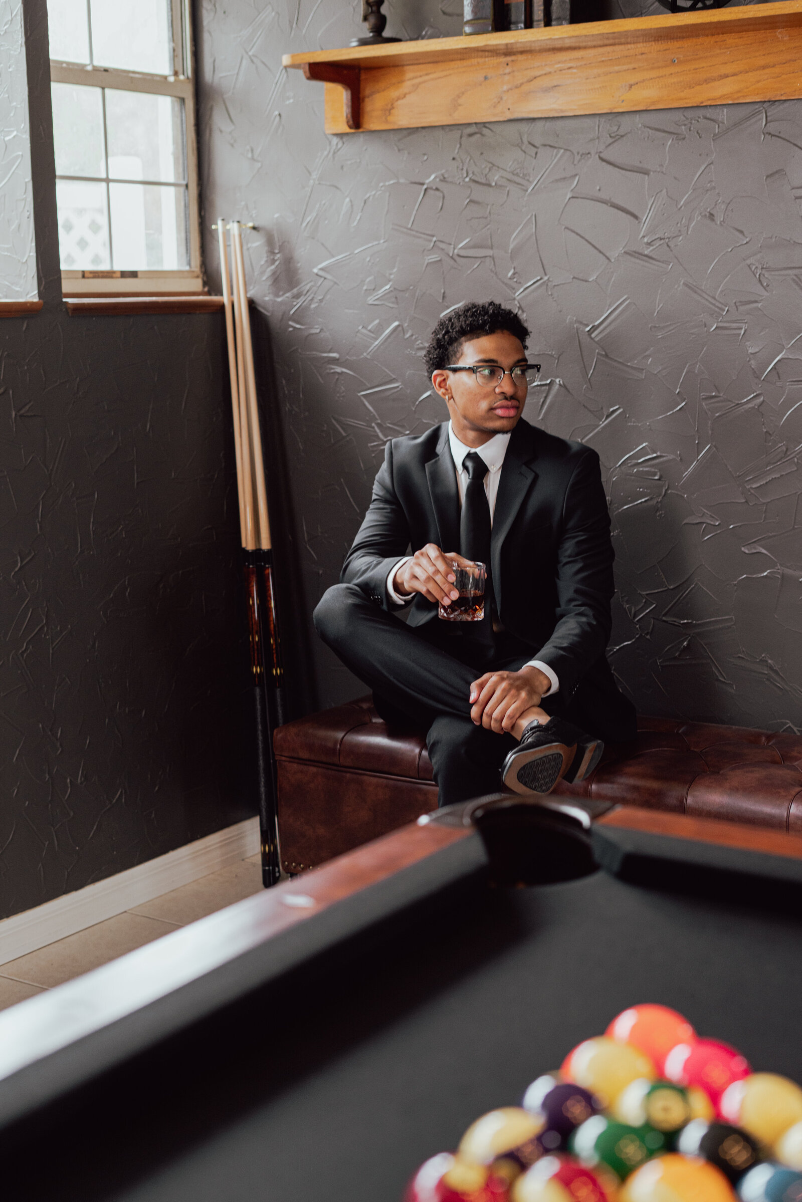 Groom drinking while playing pool