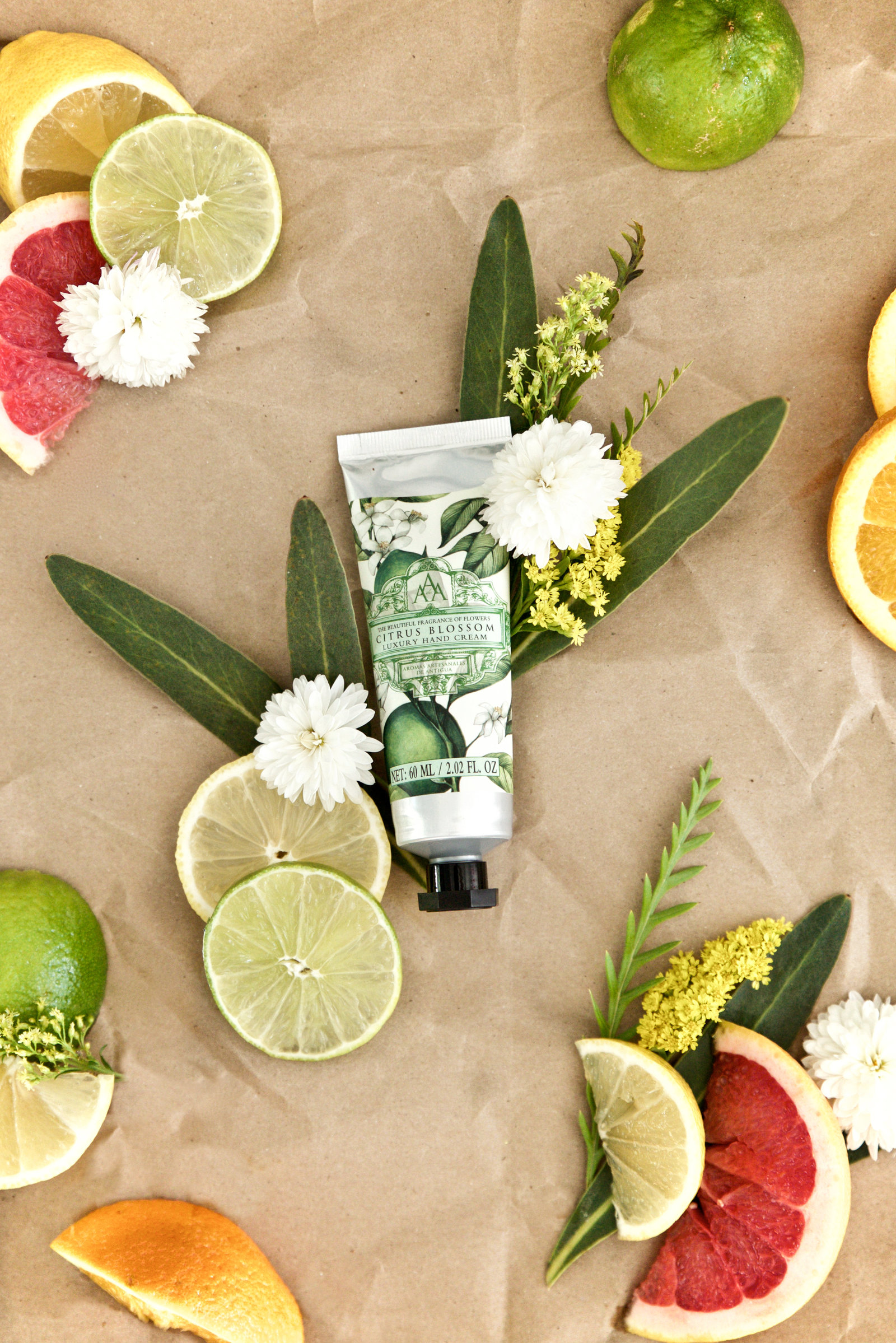 Flat Lay with Fruit Styling for natural skincare lotion company featuring grapefruit lime  flowers natural elements